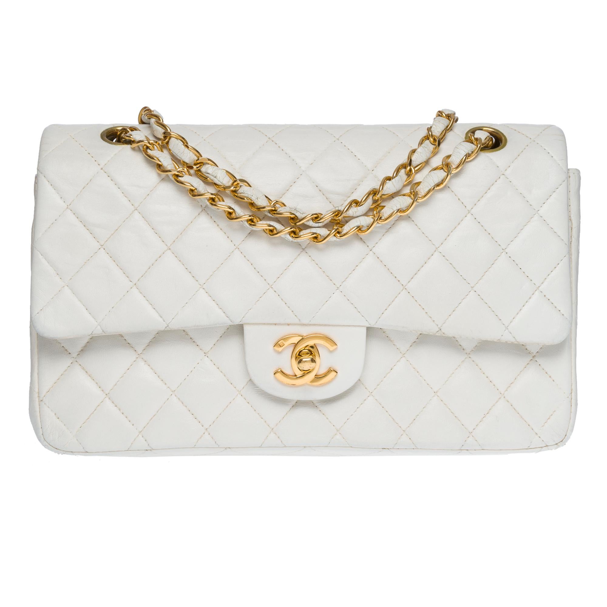 Chanel Timeless Medium 25 cm double flap shoulder bag in white quilted lambskin, gold-plated metal hardware, a gold-plated metal chain handle interwoven with white leather for a hand or shoulder support

Gold metal flap closure
Patch pocket on back