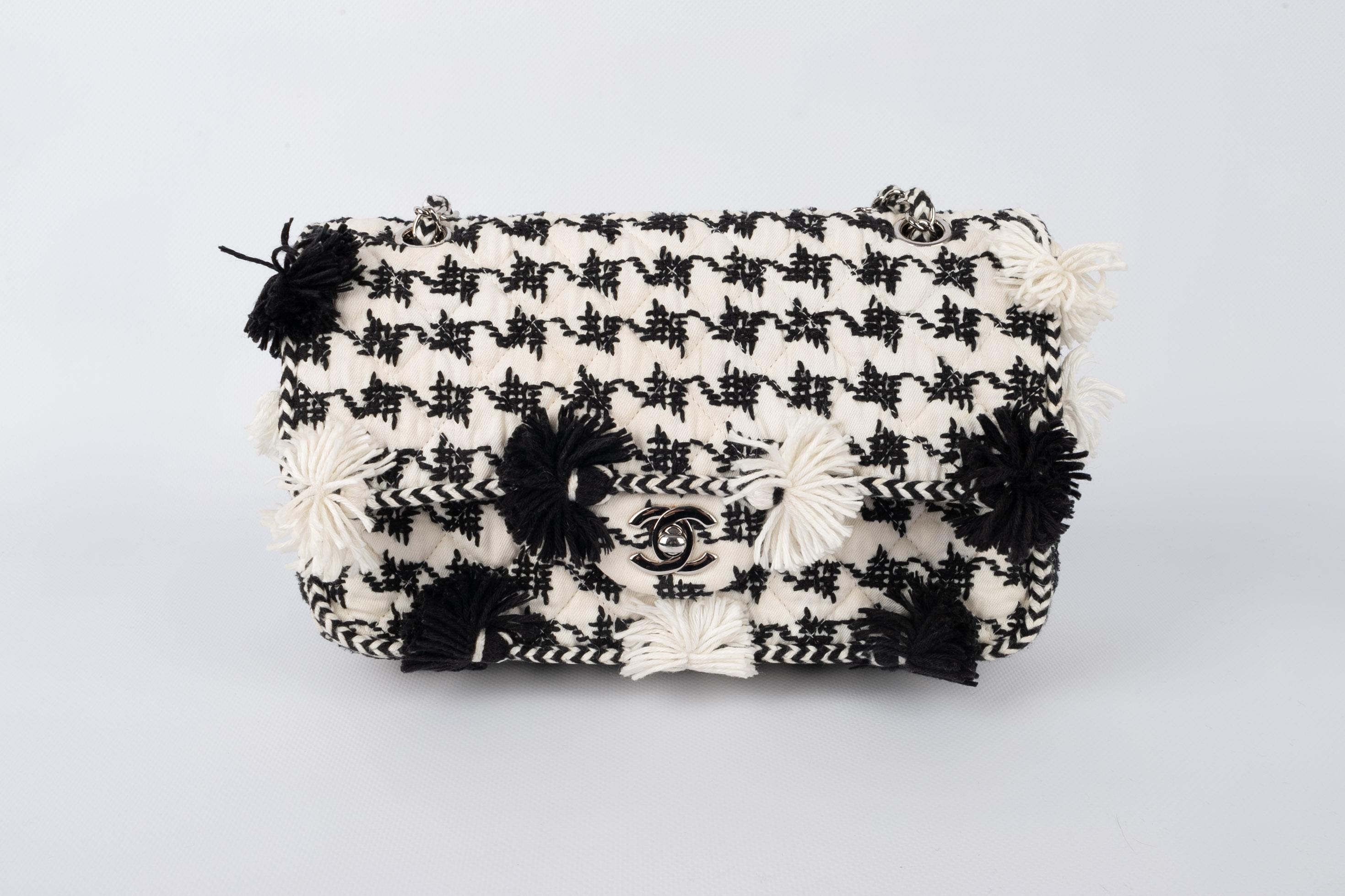 CHANEL - (Made in France) Black and white bag ornamented with pompoms and silvery metal elements. Bag with a serial number. 2015 Resort Collection.

Condition:
Good condition

Dimensions:
Length: 26 cm - Height: 18 cm - Depth: 7 cm - Handle length: