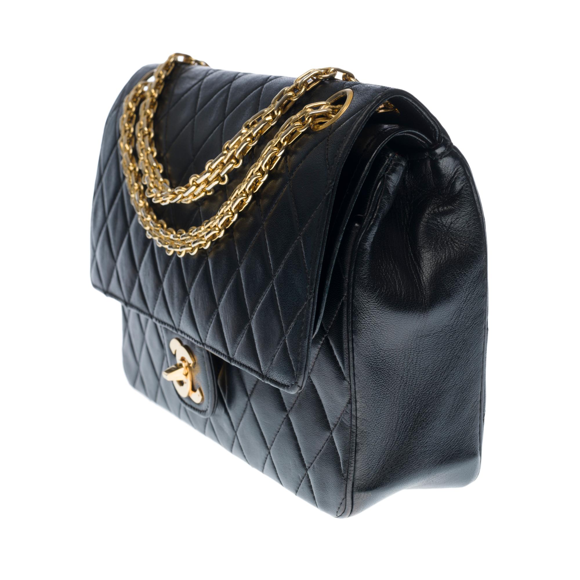 Beautiful Chanel Timeless/Classique handbag with double flap in black quilted lambskin leather, gold metal hardware, a Mademoiselle chain handle in gold metal allowing a hand or shoulder support

Closure with gold metal flap
A patch pocket on the