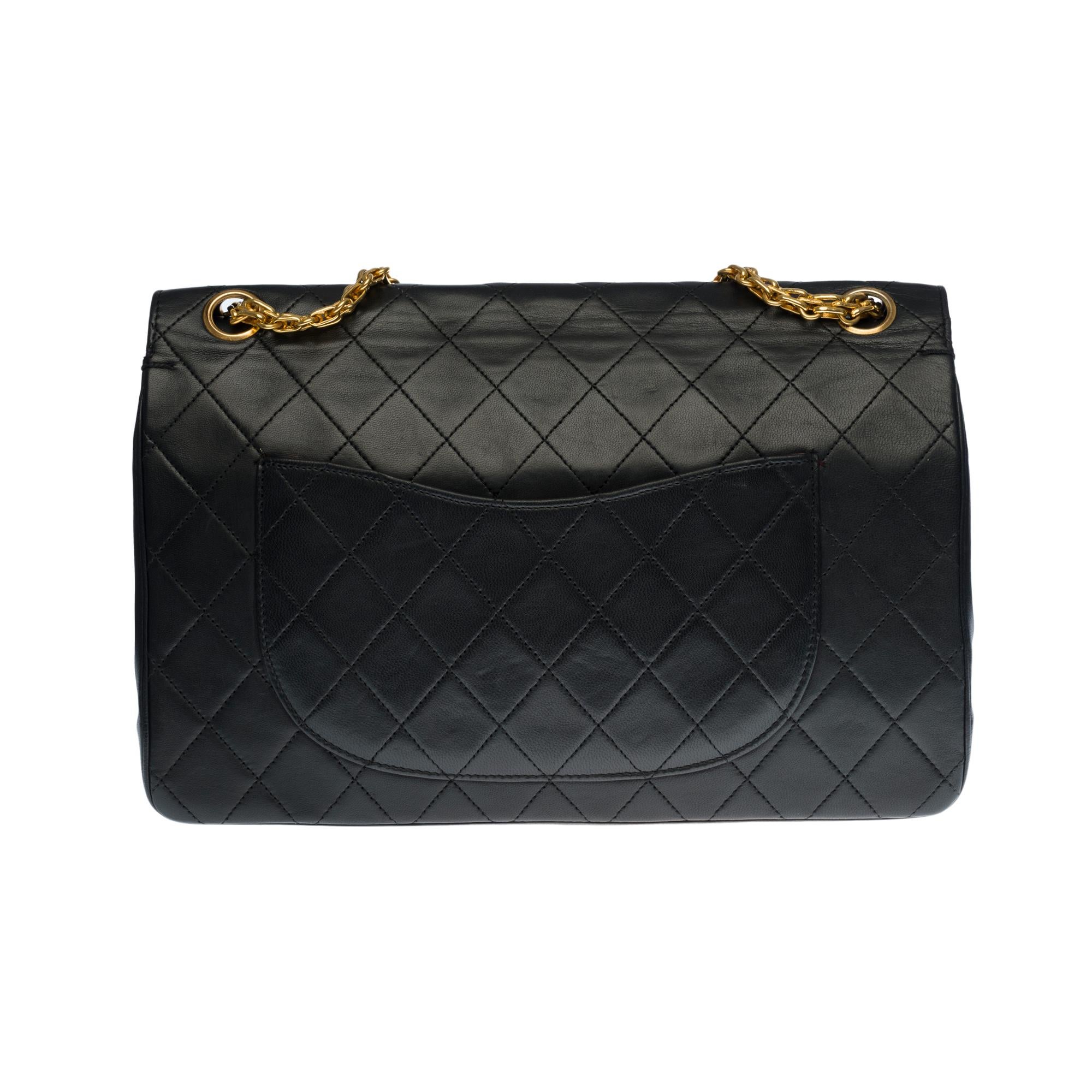 Beautiful Chanel Timeless/Classique handbag with double flap in black quilted lambskin leather, gold metal hardware, a Mademoiselle chain handle in gold metal allowing a hand or shoulder support

Closure with gold metal flap
A patch pocket on the