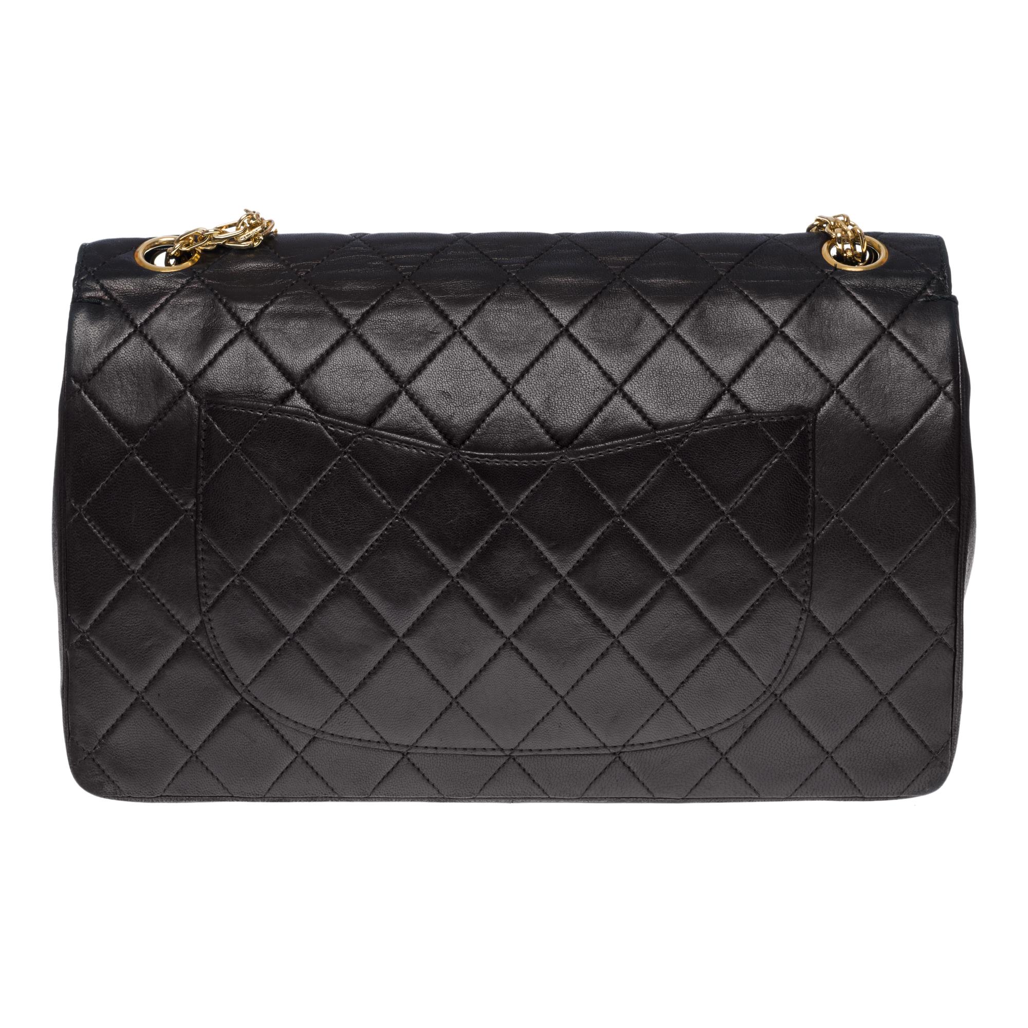 Splendid Chanel Timeless/Classic handbag with double flap in black quilted lamb leather, gold-plated metal hardware, a Mademoiselle gold-plated metal chain handle for a hand or shoulder support

A patch pocket on the back of the bag
Inner lining in