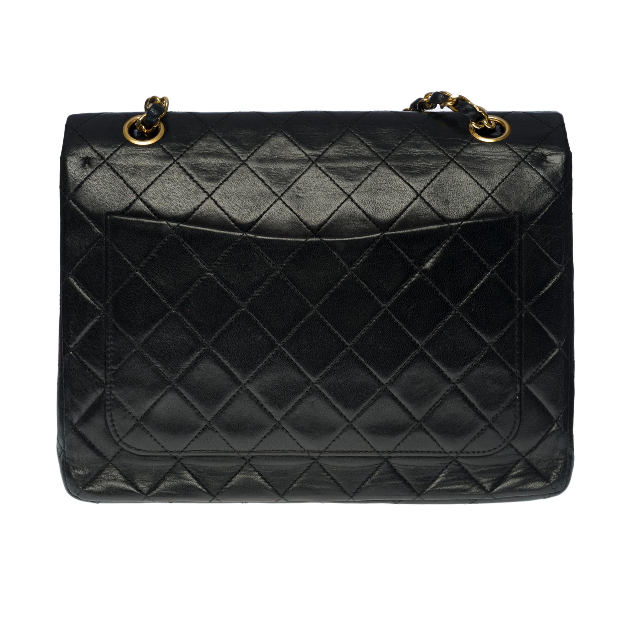 The coveted Chanel Timeless/Classic medium 25cm bag with double flap in black quilted leather, gold-plated hardware, gold-plated chain interlaced with black leather for a shoulder and shoulder strap

Backpack pocket
Flap closure with gold CC logo