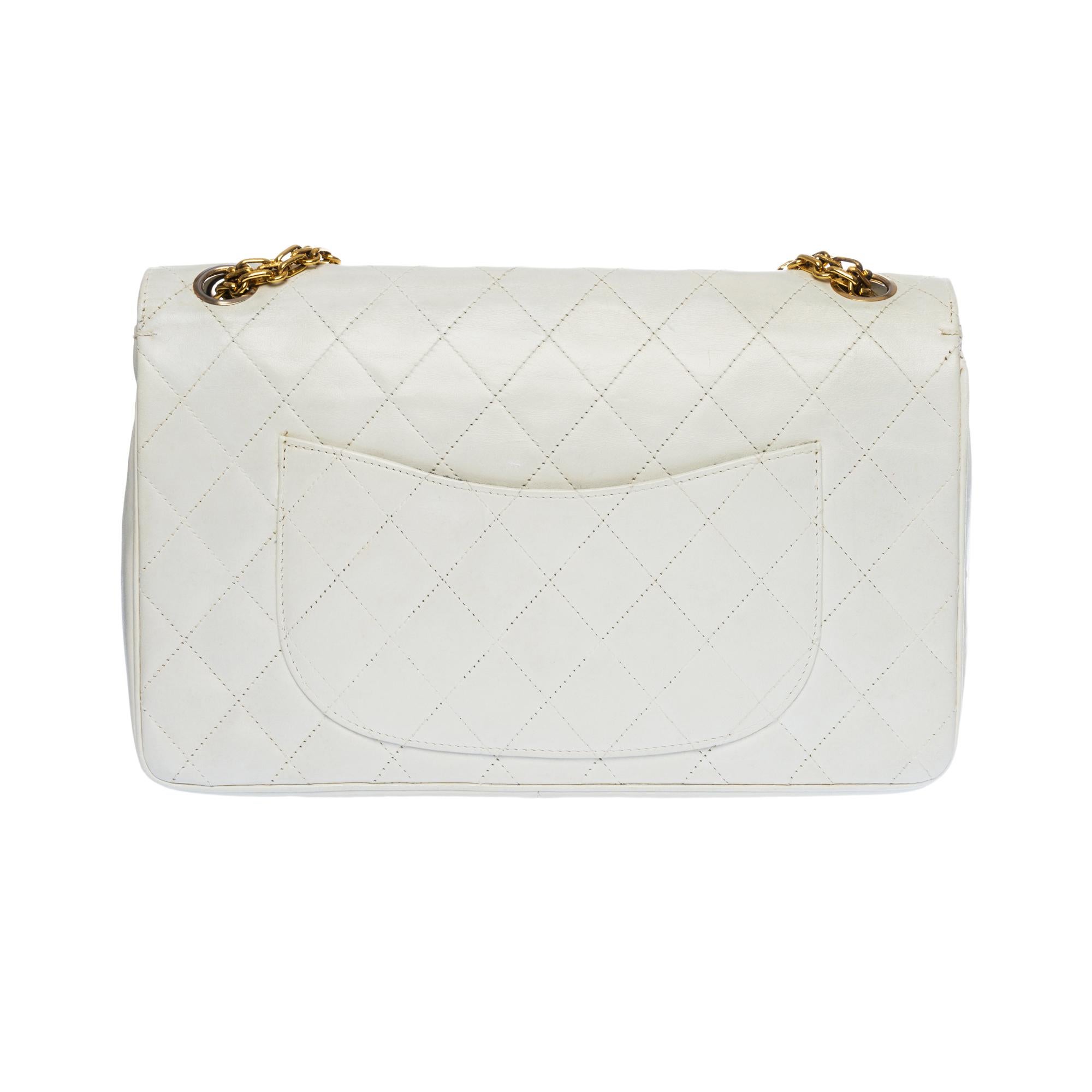 Beautiful Chanel Timeless/Classique handbag with double flap in white quilted lambskin leather, gold metal hardware, a Mademoiselle chain handle in gold metal allowing a hand or shoulder support
Closure with gold metal flap
A patch pocket on the