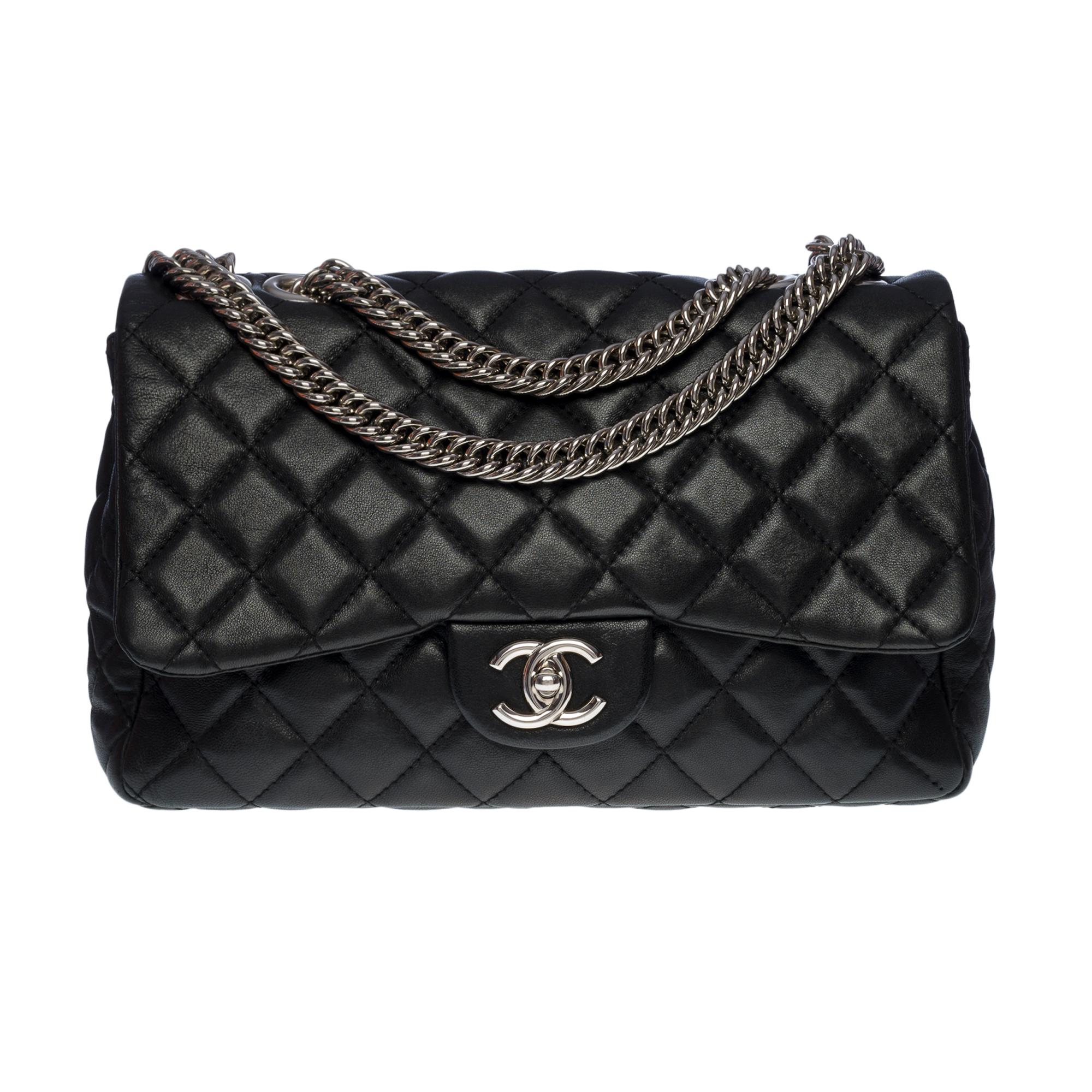 Exceptional Chanel Timeless/Classique Jumbo Single flap bag in black quilted leather, silver metal hardware, flat silver metal chain handle for a shoulder carry

Patch pocket on back of bag
Flap closure, silver CC clasp
Single flap
Burgundy leather