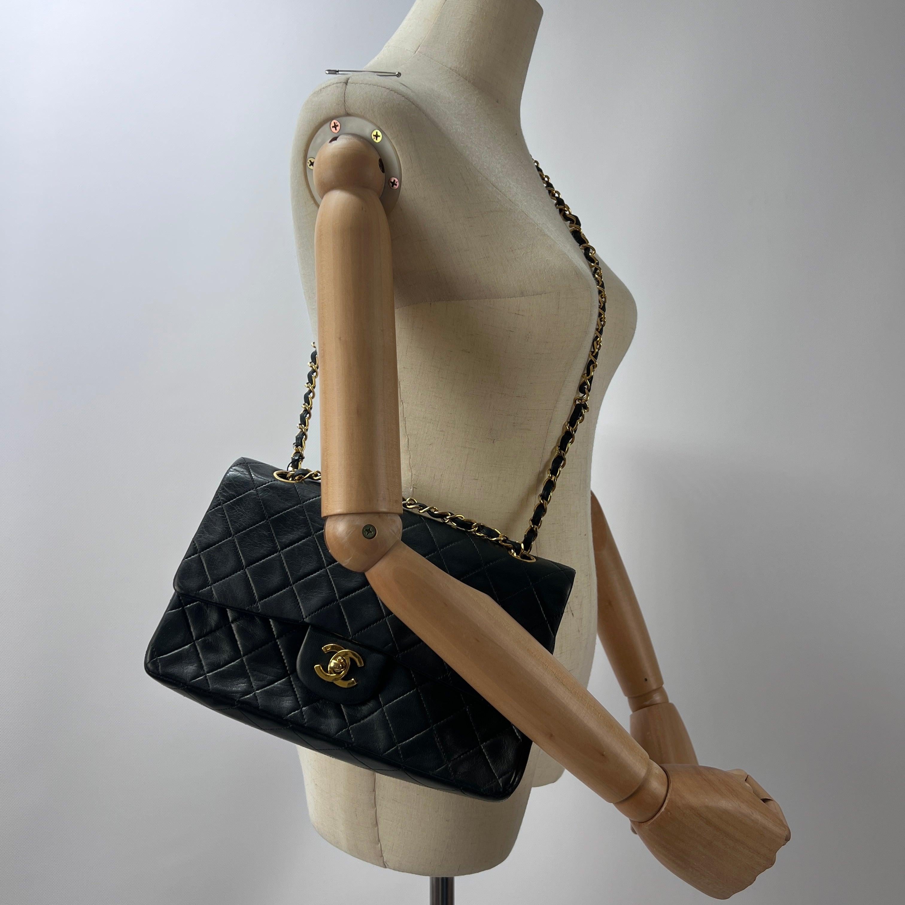 Magnifica borsa a tracolla Chanel modello Timeless Classique Medium Double Flap, realizzata in pelle d'agnello noir matelassé e ornata da una bijouterie dorée placcata o 24 carati. Il modello, prodotto alla fine degli anni '80 sotto la direzione di