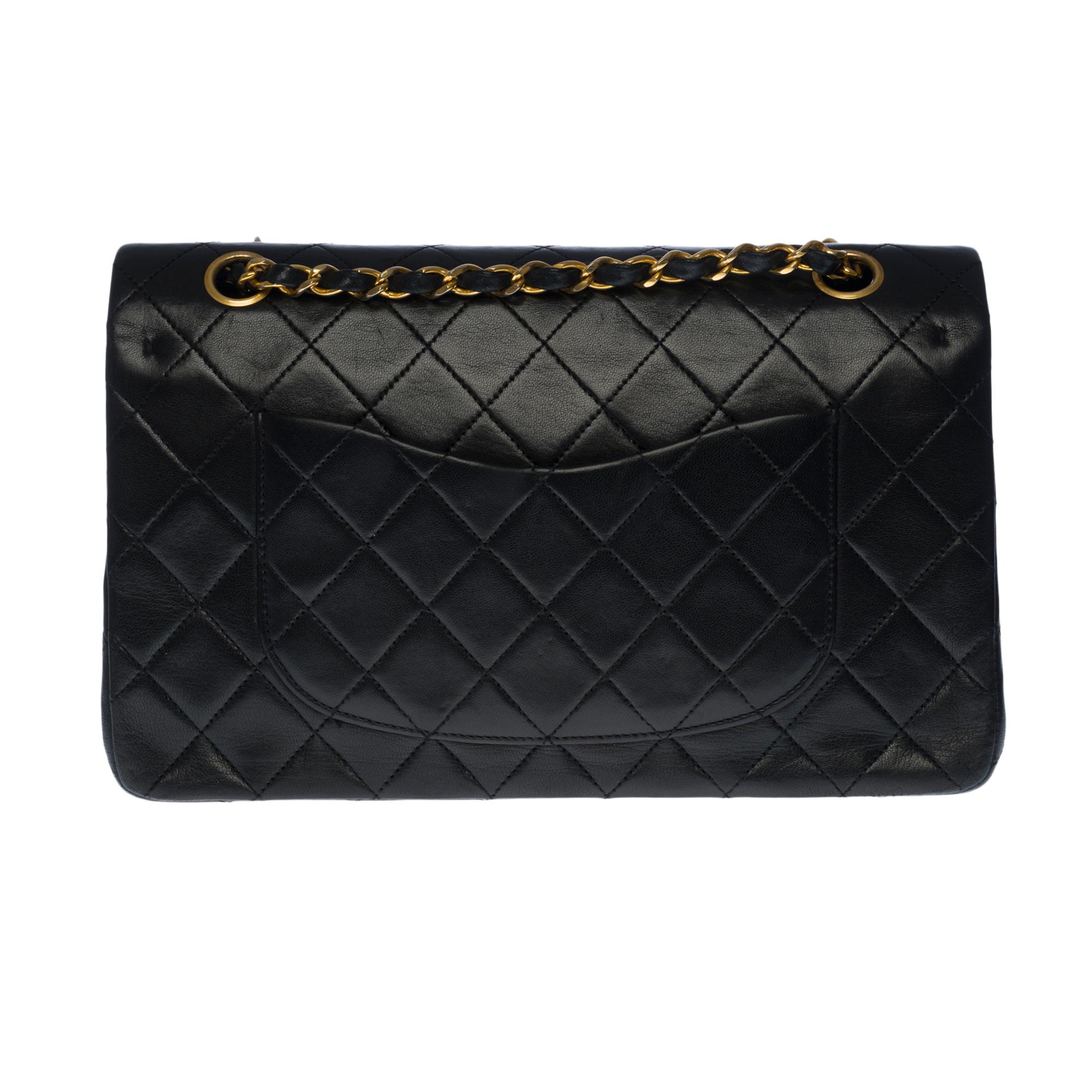 Beautiful Chanel Timeless Medium 25cm handbag with double flap in black quilted lambskin leather, gold-tone metal hardware, a gold-tone metal chain handle interwoven with black leather allowing a hand or shoulder support.

Closure with gold metal