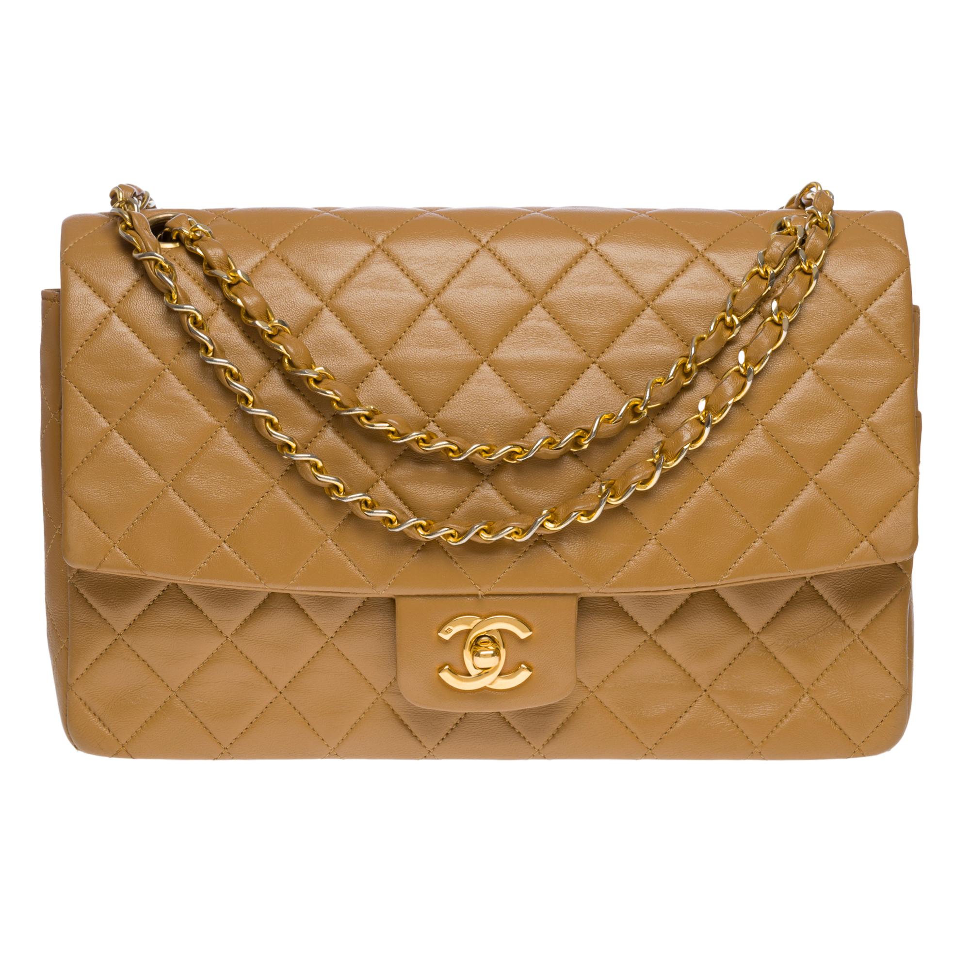 The Classy Chanel Timeless/Classic shoulder flap bag in beige quilted lambskin leather, gold metal hardware, a gold metal chain handle interlaced with beige leather for a shoulder or crossbody carry

Pocket on the back of the bag
Closure by flap,