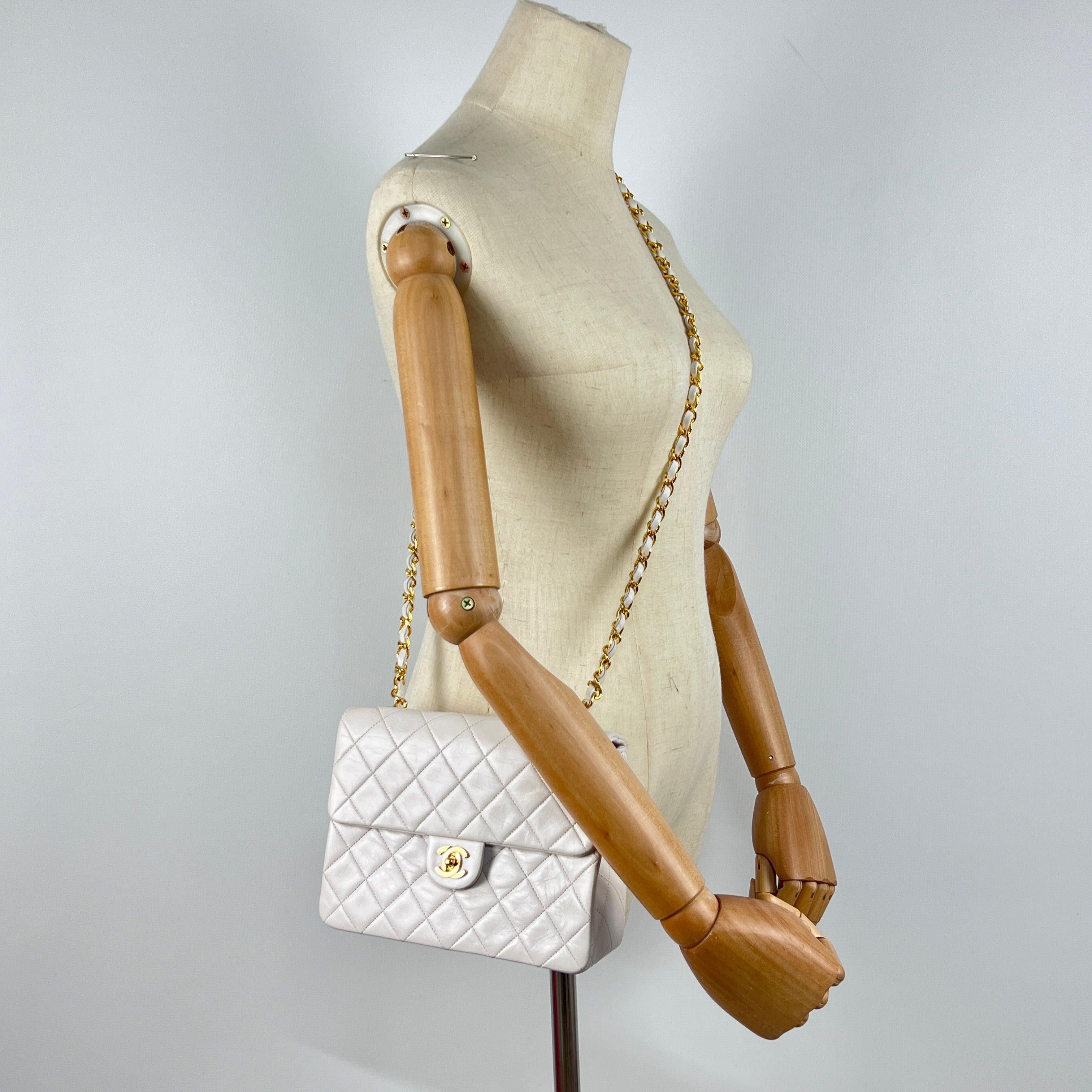 Magnifique sac à main CHANEL modèle Timeless Classique Small Single Flap, réalisé en cuir d’agneau blanc et orné d’une bijouterie dorée plaquée or 24 carats. Ce modèle iconique, produit à la fin des années 1980 sous la direction de Karl Lagerfeld,