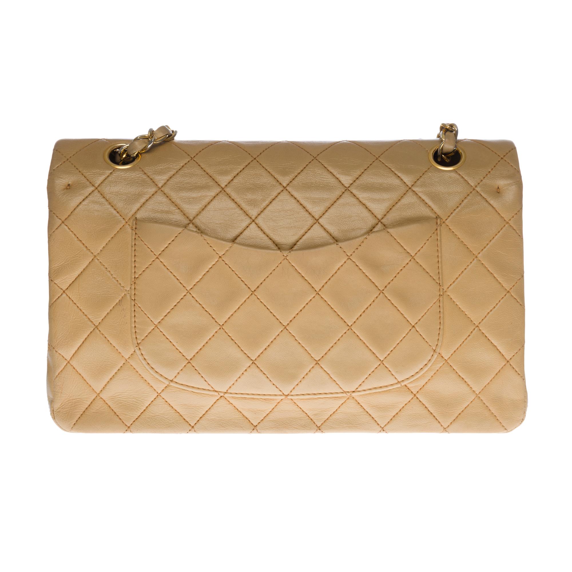 Beautiful Chanel Timeless/Classique handbag with double flap in beige quilted lambskin leather, gold-tone metal hardware, a golden metal chain handle intertwined with beige leather allowing a hand, shoulder and shoulder strap
Closure with gold metal