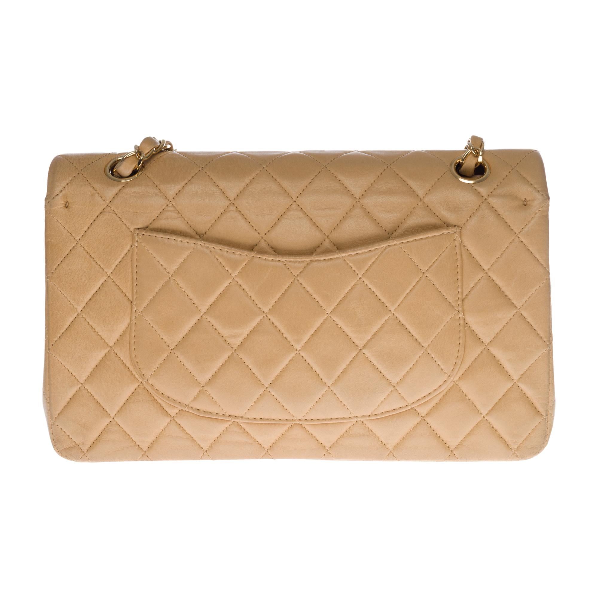 Beautiful Chanel Timeless/Classique handbag with double flap in beige quilted lambskin leather, gold-tone metal hardware, a golden metal chain handle intertwined with beige leather allowing a hand, shoulder and shoulder strap
Closure with gold metal