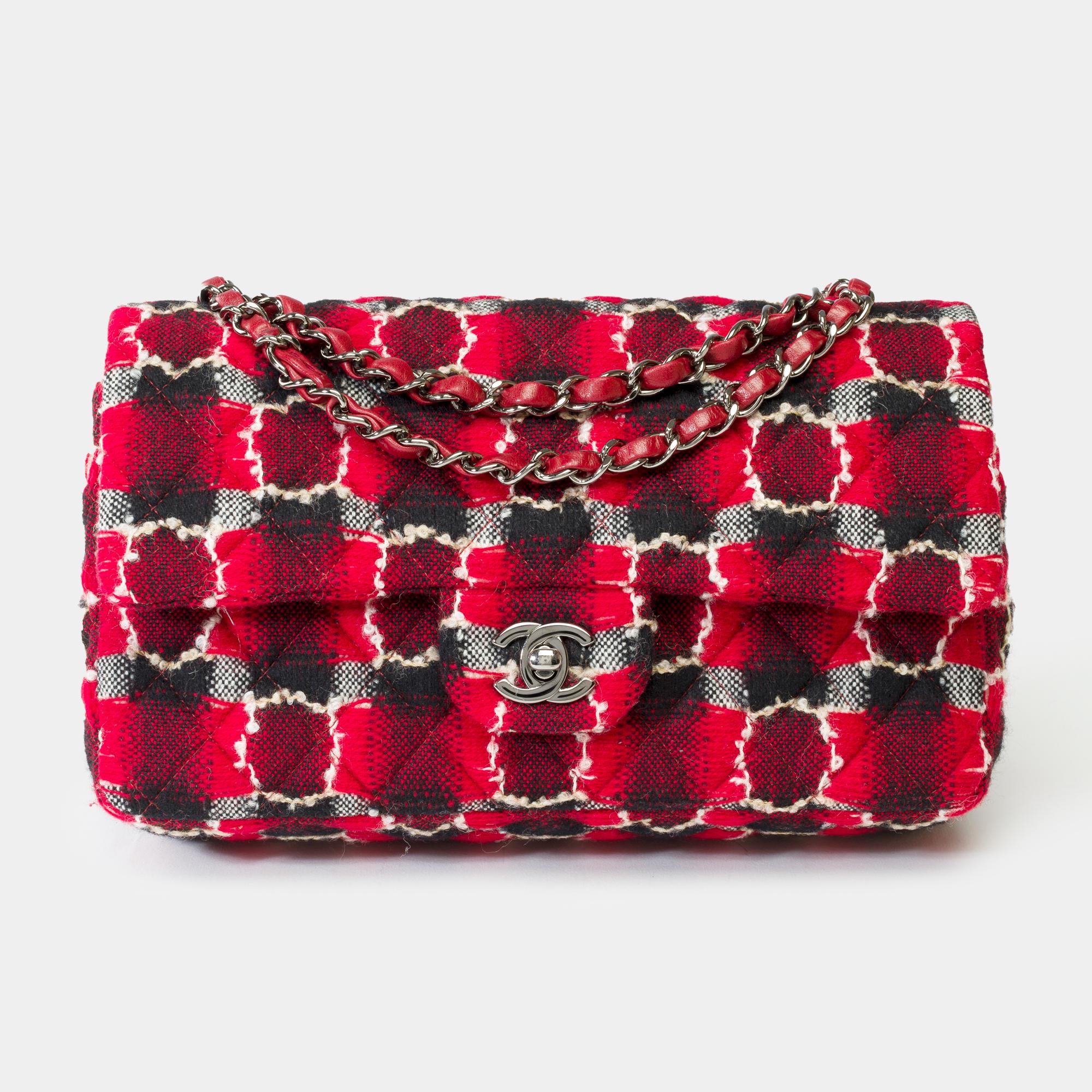 Precioso bolso Chanel Timeless de doble solapa en Tweed acolchado rojo negro y gris , adornos de metal plateado, asa de metal plateado entrelazada con cuero rojo para llevarlo en la mano o al hombro

Cierre mediante solapa en metal plateado
Un