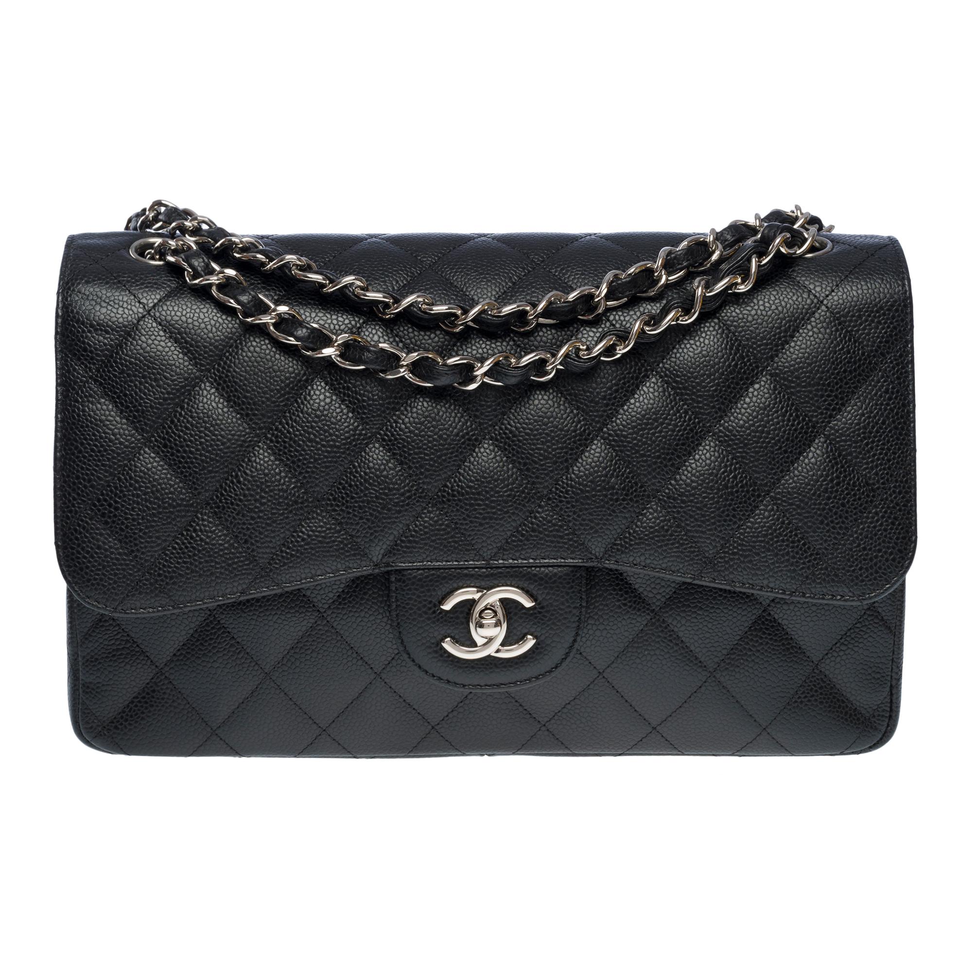 Exceptional Chanel Timeless Jumbo double flap shoulder bag in black caviar quilted leather, silver metal hardware, a chain-handle in silver interlaced with black caviar leather for a hand and shoulder carry

A patch pocket on the back of the