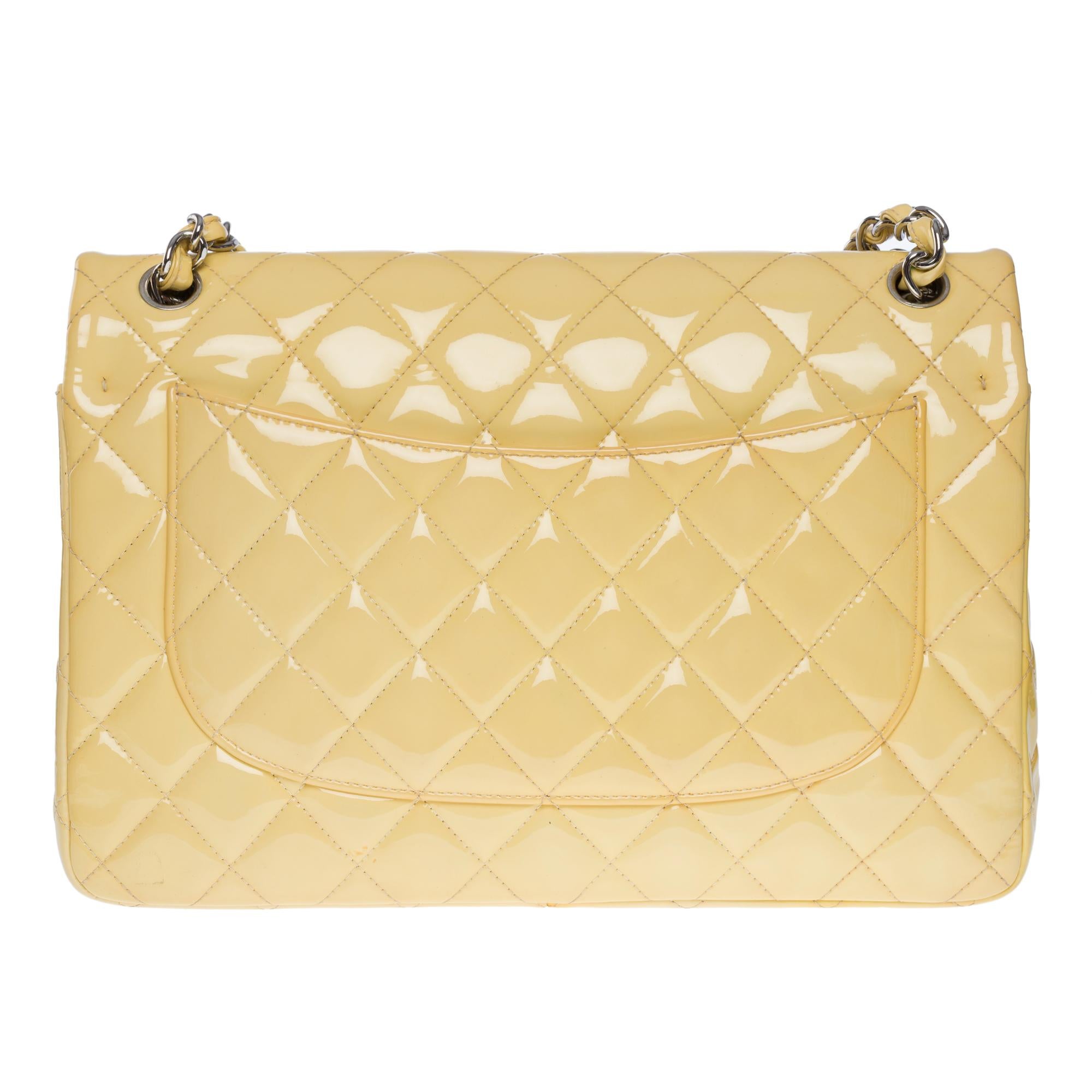 Beautiful Chanel Timeless jumbo double flap shoulder bag in yellow quilted patent leather, silver metal hardware, silver silver chain handle interwoven with yellow patent leather for a hand or shoulder or crossbody

Silver metal logo closure on