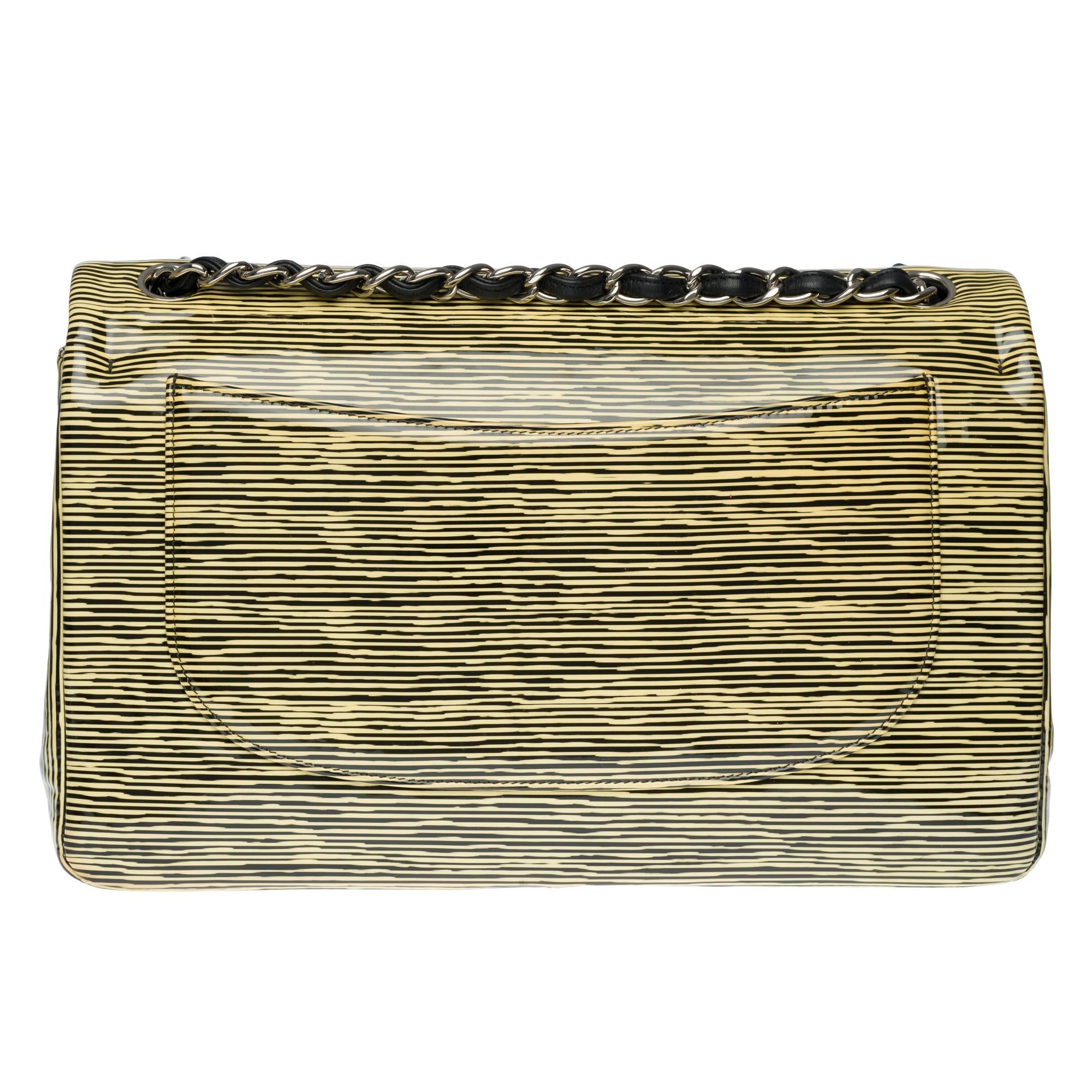 Beautiful Handbag Chanel Timeless Jumbo with double flap in yellow and black patent leather, silver metal hardware, a silver metal chain handle intertwined with black leather allowing a hand or shoulder or shoulder strap.

Silver metal flap