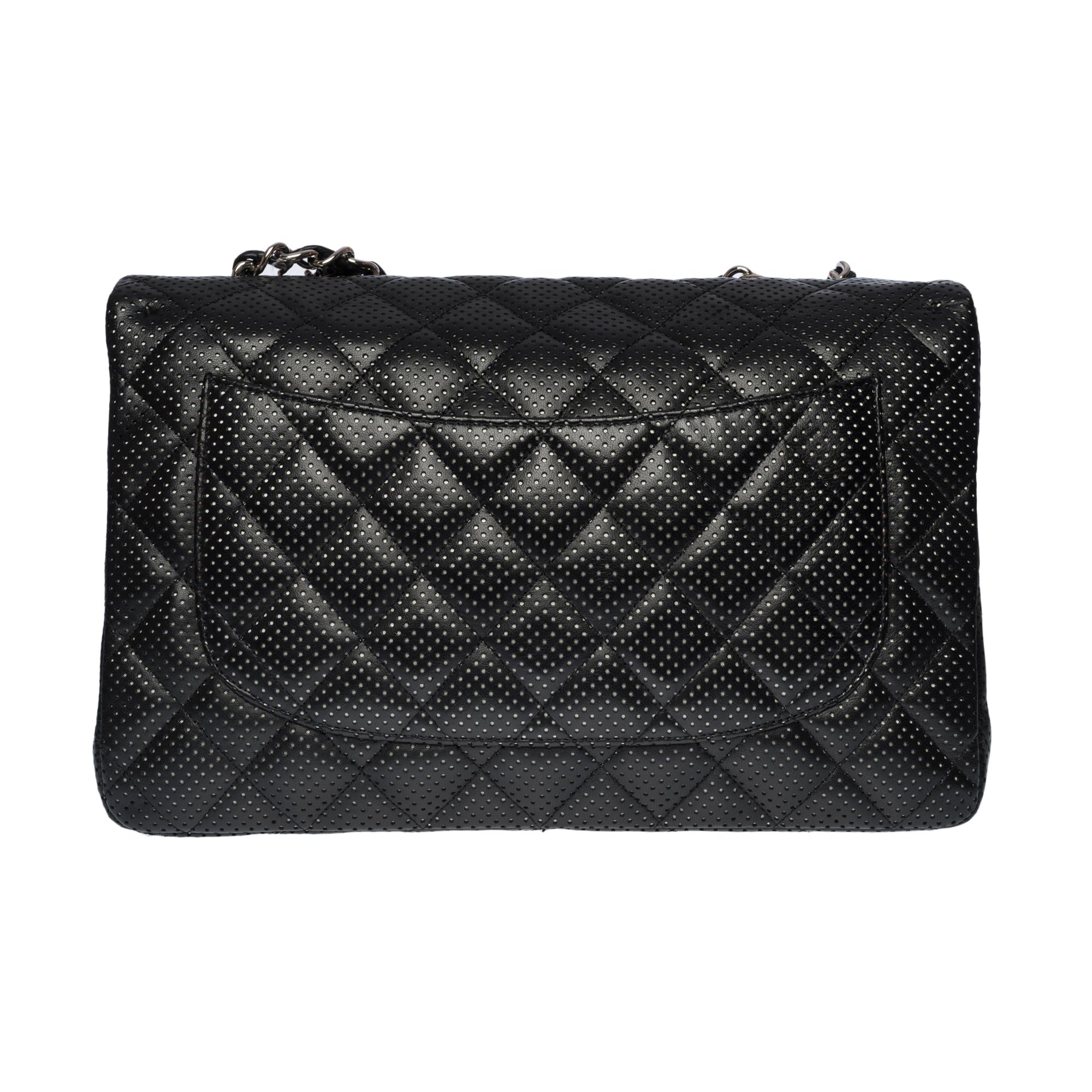 The Majestic Shoulder Bag Chanel Timeless Jumbo Flap bag in black quilted perforated leather, silver metal hardware, silver metal chain handle interwoven with black leather for a hand or shoulder or shoulder strap

Silver metal logo closure on