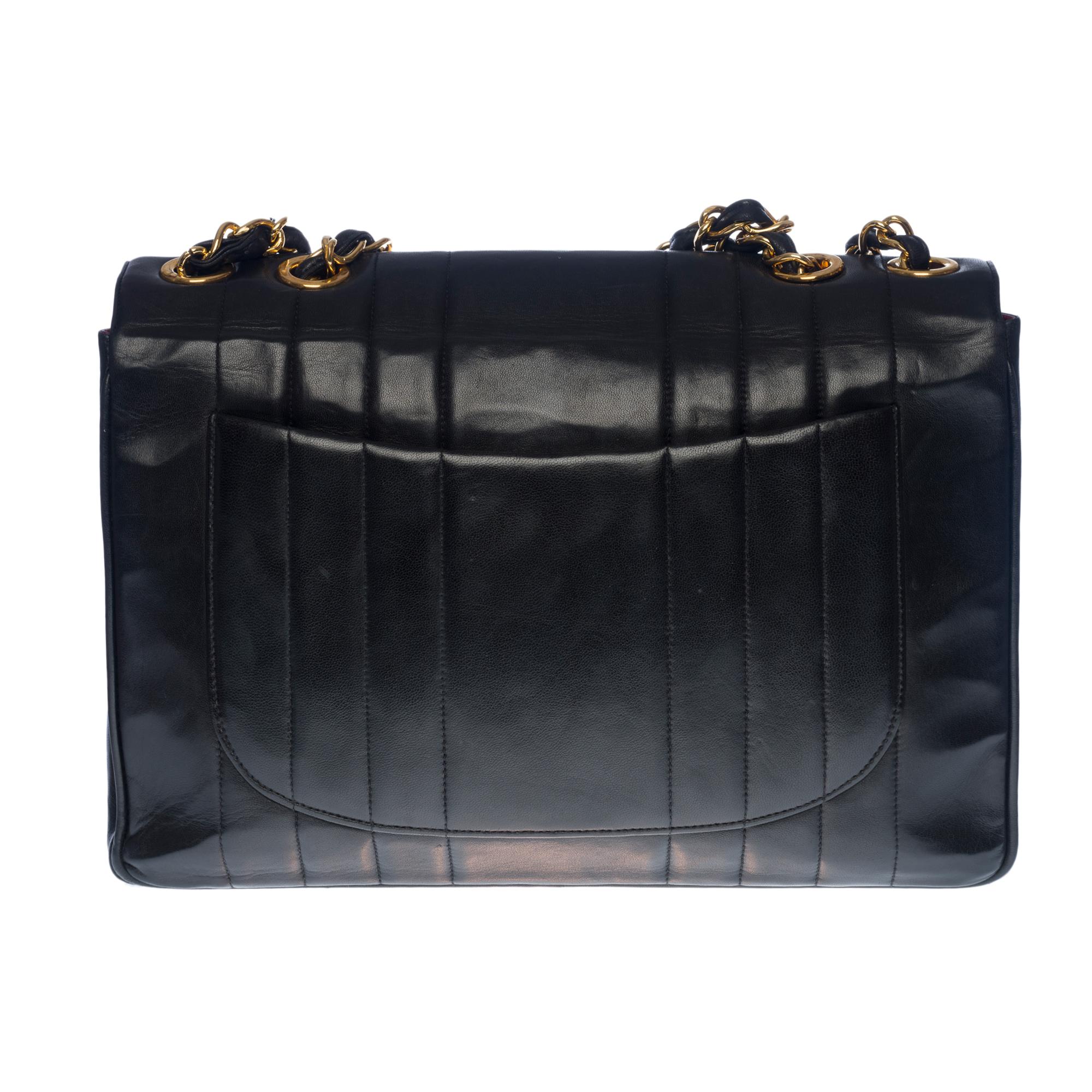 Majestic Chanel Jumbo single flap bag in black quilted lambskin leather with vertical stitching, gold-plated metal hardware, gold-plated metal chain handle interlaced with black leather for shoulder support

Flap closure, gold CC logo clasp
Bordeaux