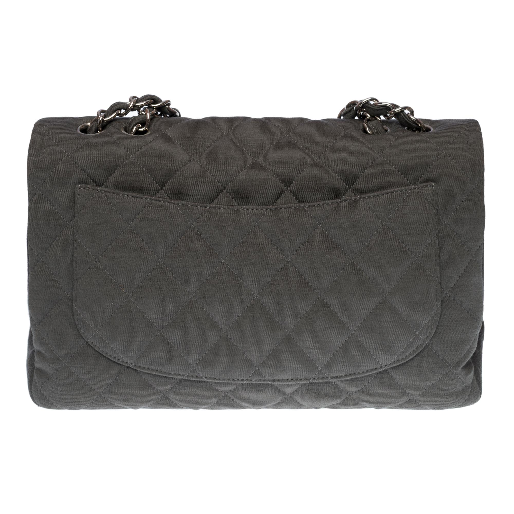 Beautiful Chanel Timeless Jumbo single flap shoulder bag in grey quilted jersey, silver metal hardware, a silver metal chain handle interwoven with grey jersey. allowing a hand, shoulder and crossbody support

Silver metal flap closure
A patch