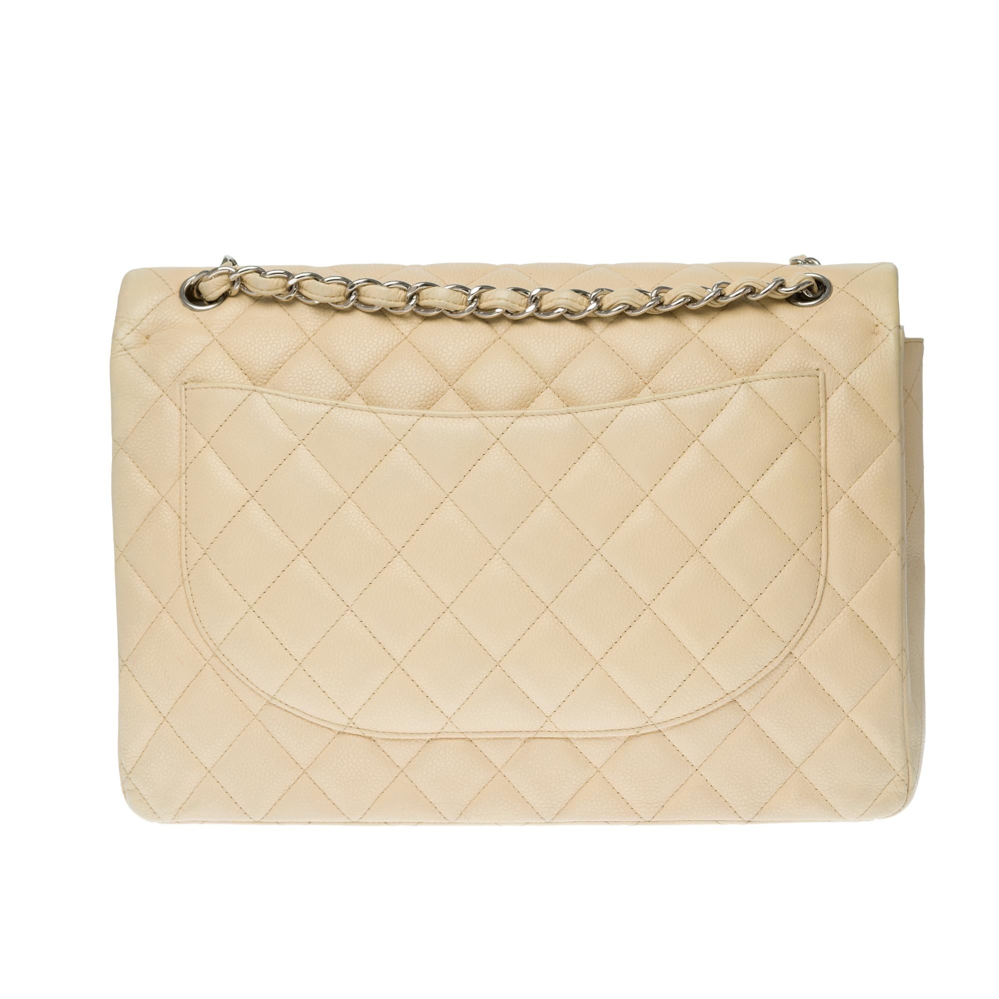 The Majestic shoulder bag Chanel Timeless Maxi jumbo in beige quilted grained leather, silver metal hardware, silver metal chain handle intertwined with beige leather allowing a hand or shoulder or shoulder strap.

Silver metal logo closure on