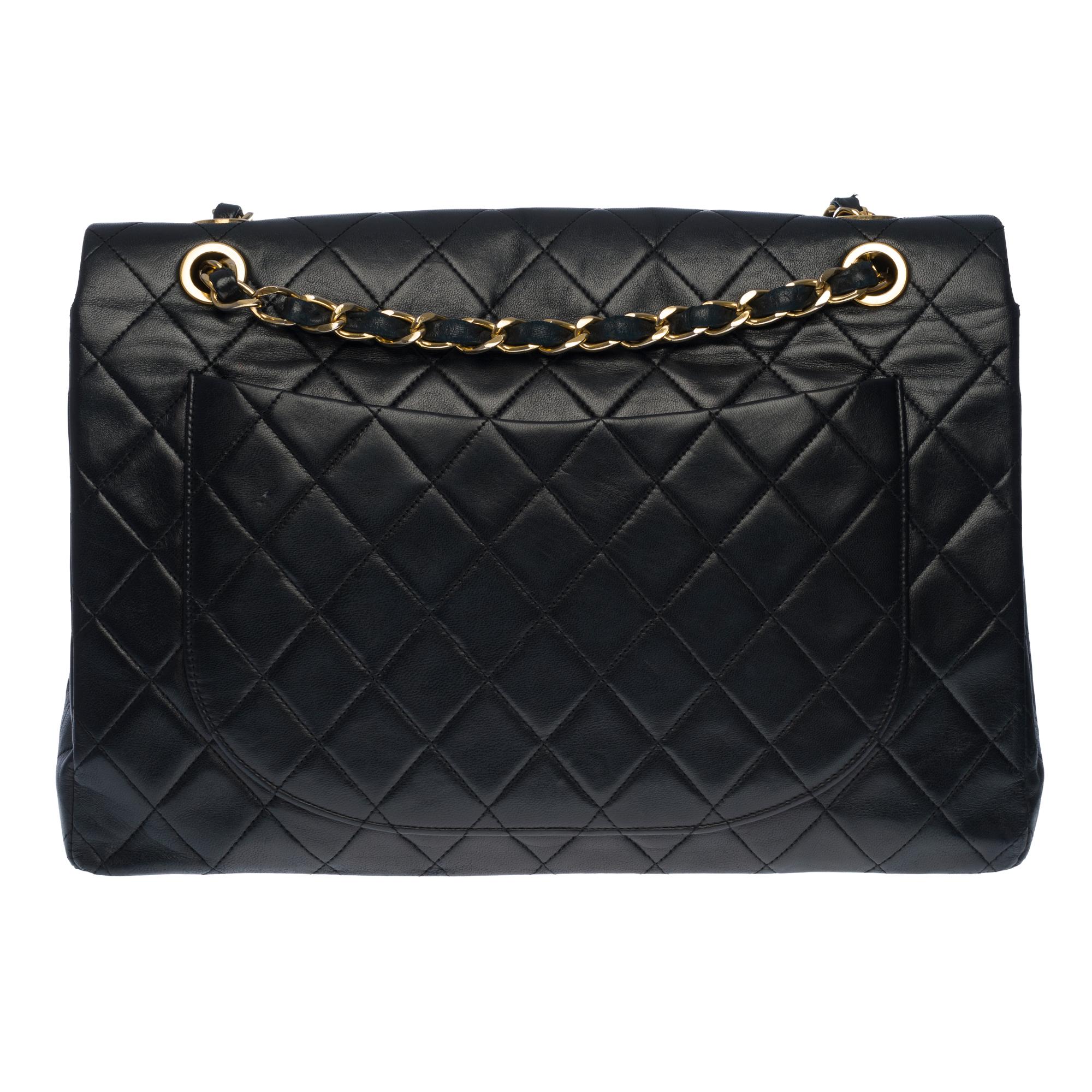 The Majestic Chanel Timeless Jumbo Handbag with simple flap in black quilted lambskin leather, gold-tone metal hardware, a gold-tone metal chain handle interwoven with black leather allowing a hand or shoulder or shoulder strap.

Closure with gold