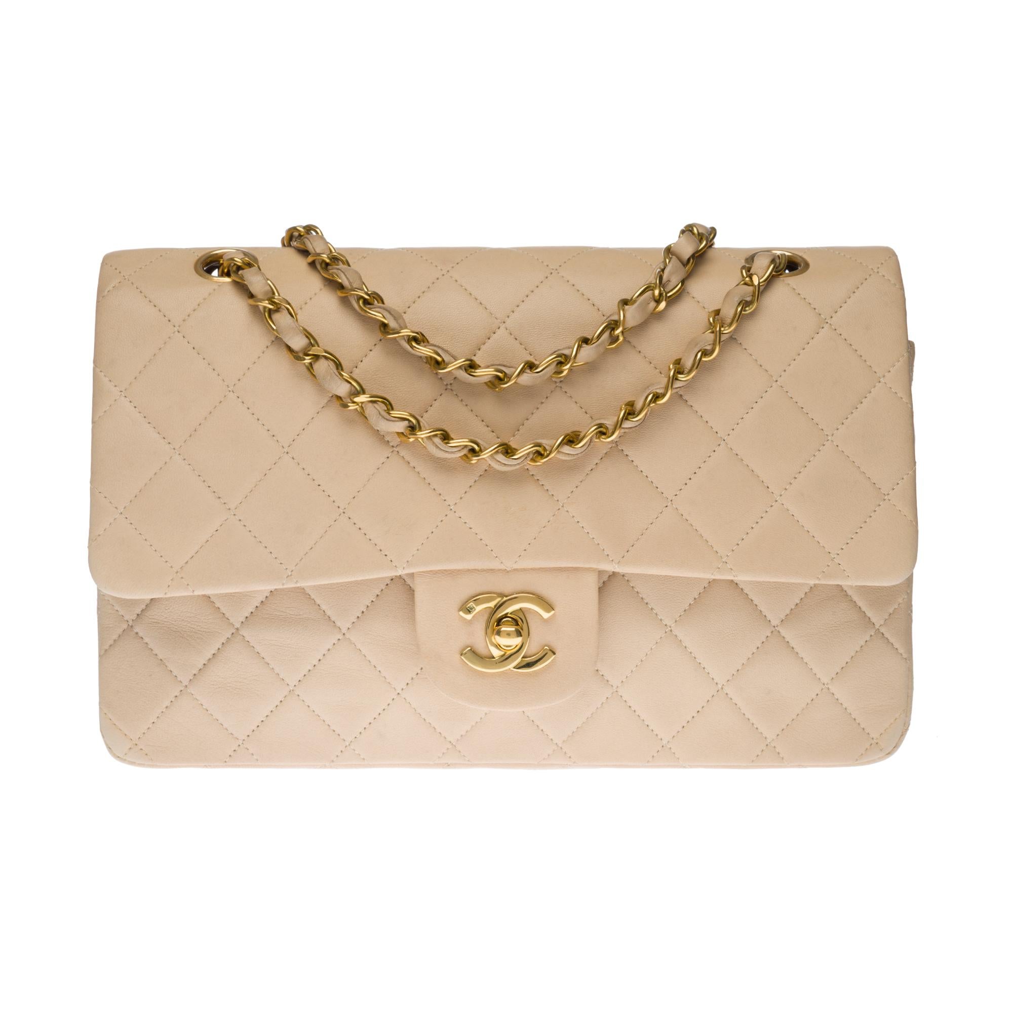 Beautiful Chanel Timeless Medium handbag with double flap in beige quilted lambskin leather, gold metal trim, a golden metal chain handle intertwined with beige leather allowing a hand or shoulder support.

Closure with gold metal flap.
A patch