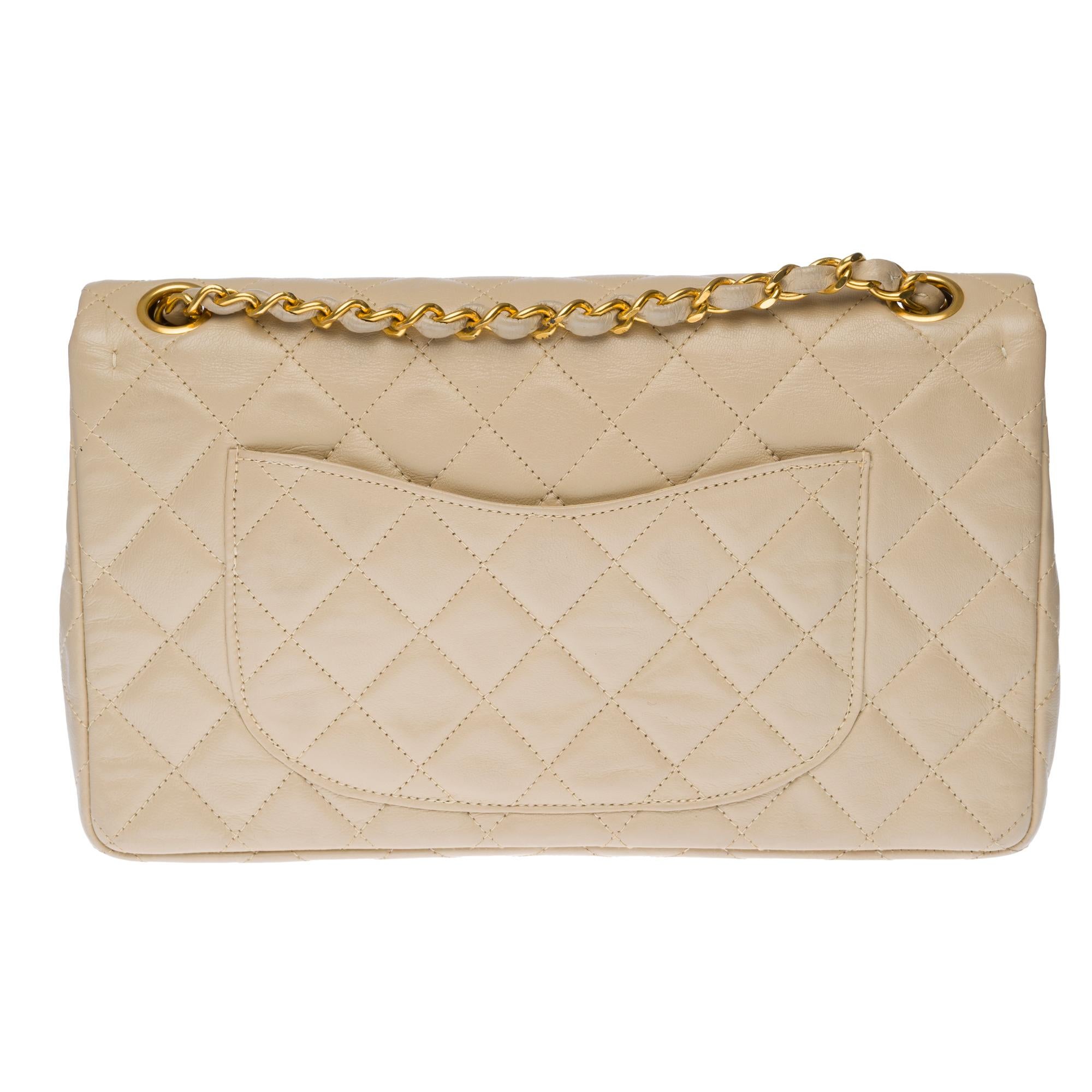 Beautiful Chanel Timeless/Classique handbag with double flap in beige quilted lambskin leather, gold-tone metal hardware, a gold-tone metal chain handle intertwined with beige leather allowing a hand or shoulder support.

Closure with gold metal
