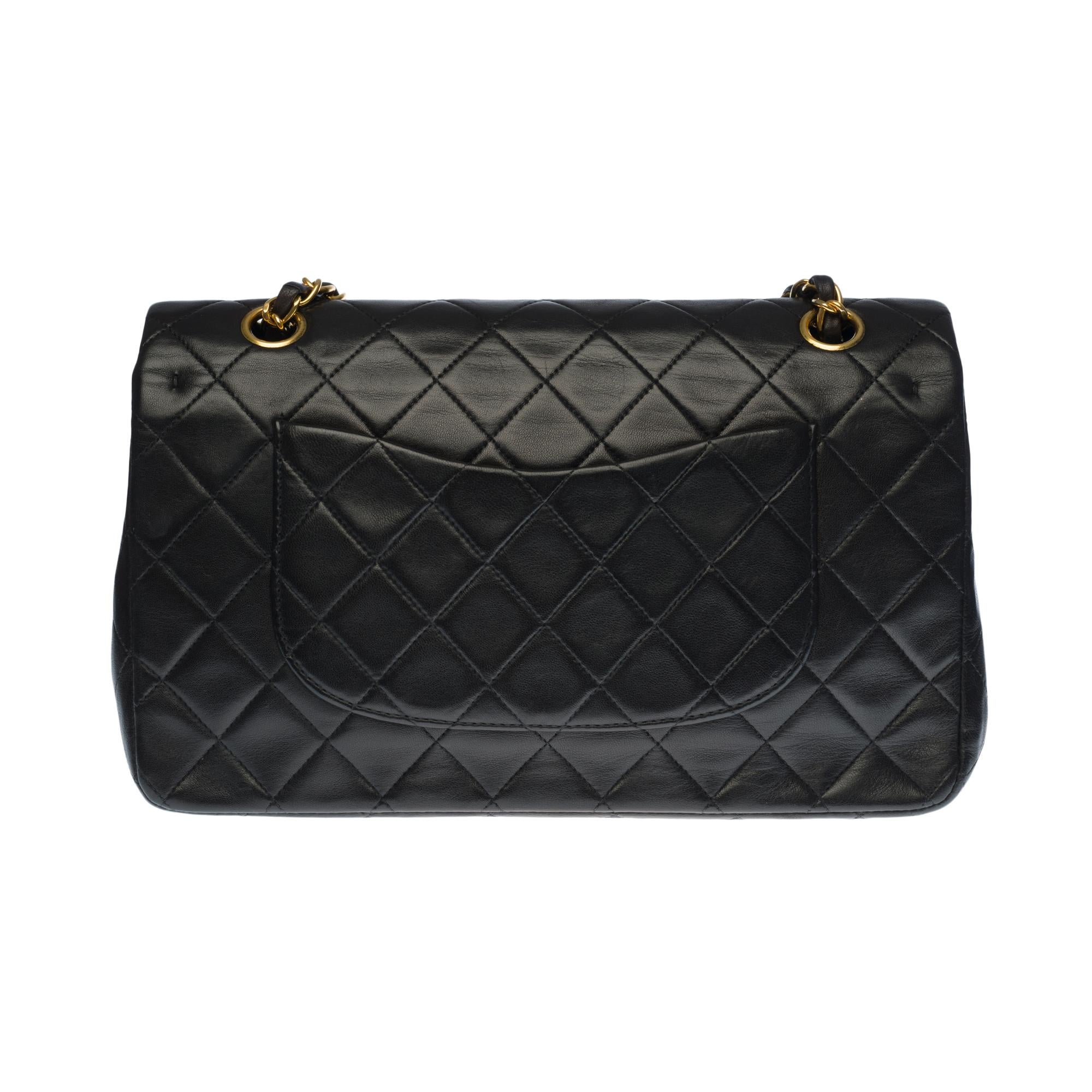 Beautiful Chanel Timeless Medium handbag with double flap in black quilted lambskin leather, gold-tone metal hardware, a gold-tone metal chain handle interwoven with black leather allowing a hand or shoulder support
Closure with gold metal flap
A