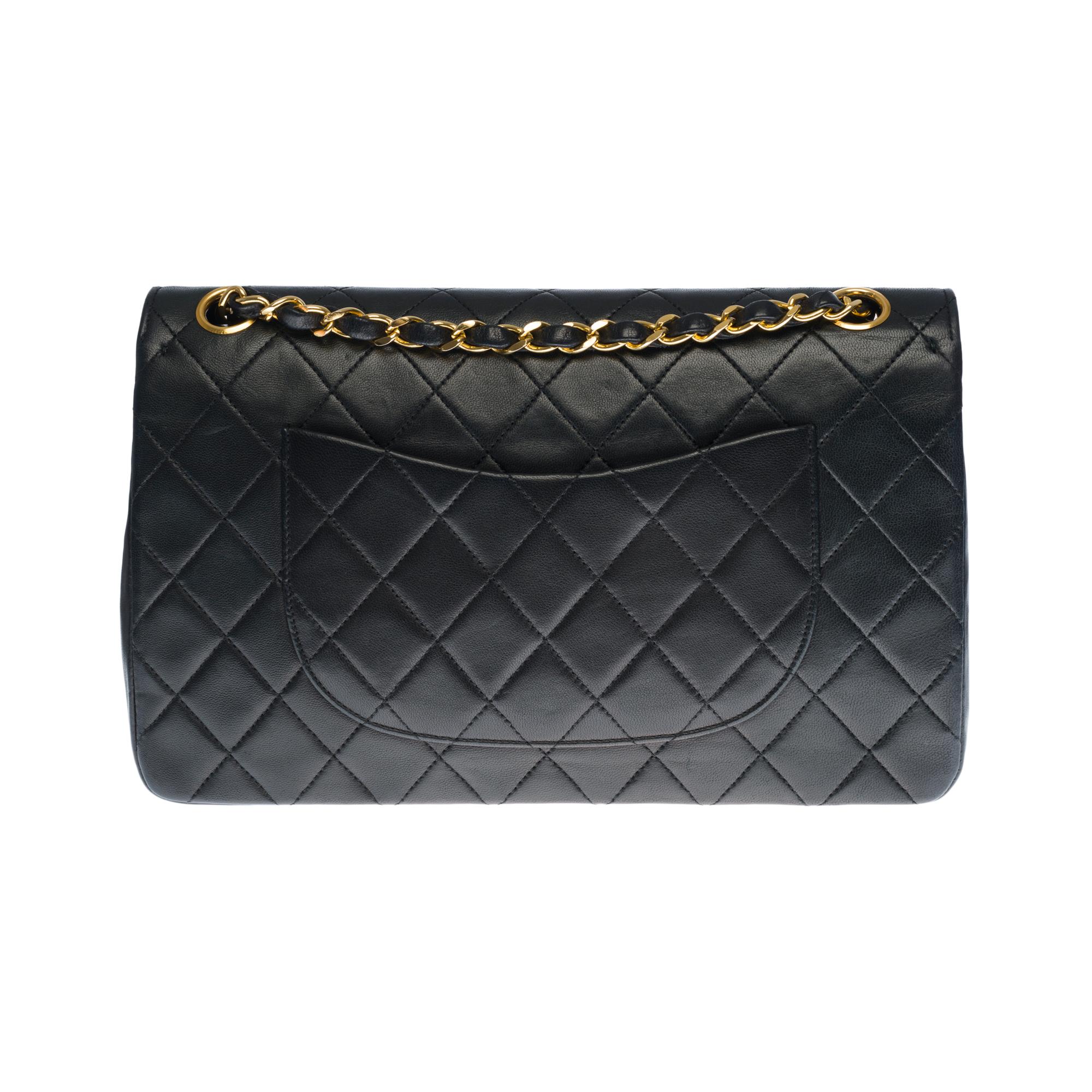 Beautiful Chanel Timeless Medium double flap shoulder bag in black quilted lambskin leather, gold-tone metal hardware, a gold-tone metal chain handle interwoven with black leather allowing a hand or shoulder carry
Closure with gold metal flap
A