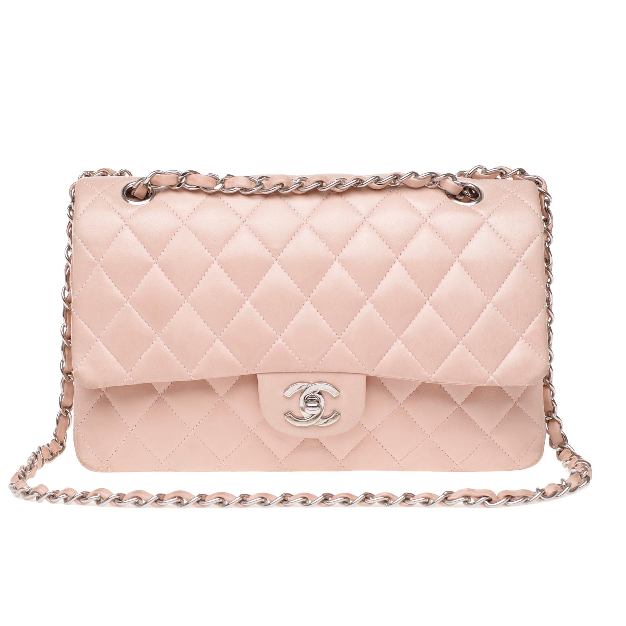 Classic Chanel Timeless handbag in pink quilted leather, silver metal trim, a silver metal chain handle intertwined with pink leather allowing a hand or shoulder or shoulder strap.

Silver metal flap closure.
A patch pocket on the back of the