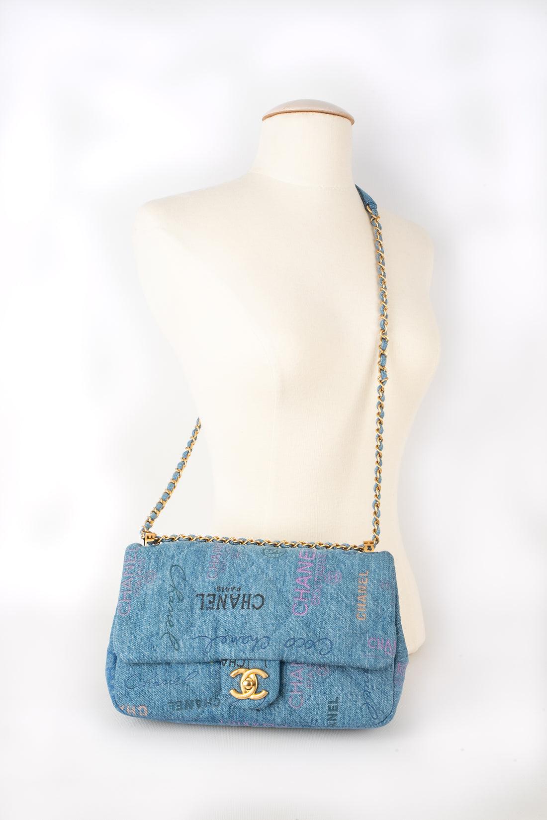 Chanel - (Made in Italy) Quilted flecked denim Timeless Classic bag printed with multicolored writings. Golden metal cc fastener with a matte finish on a flap. Adjustable chain handle interlaced coordinately. Piece with a serial number. 2022