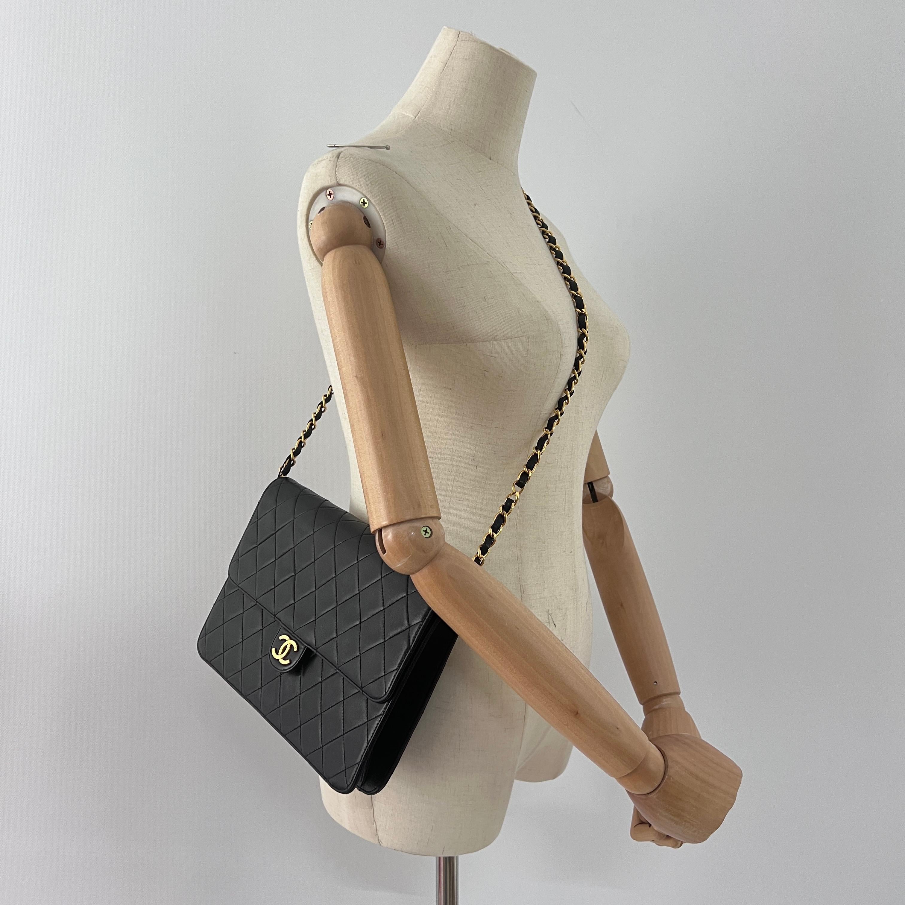 CHANEL Timeless WOC Medium en cuir noir avec des accessoires en métal doré. Le sac se ferme par un bouton-pression. L'intérieur se compose d'un compartiment principal et d'une poche plaquée zippée. Peut être porté en bandoulière. Le numéro de série