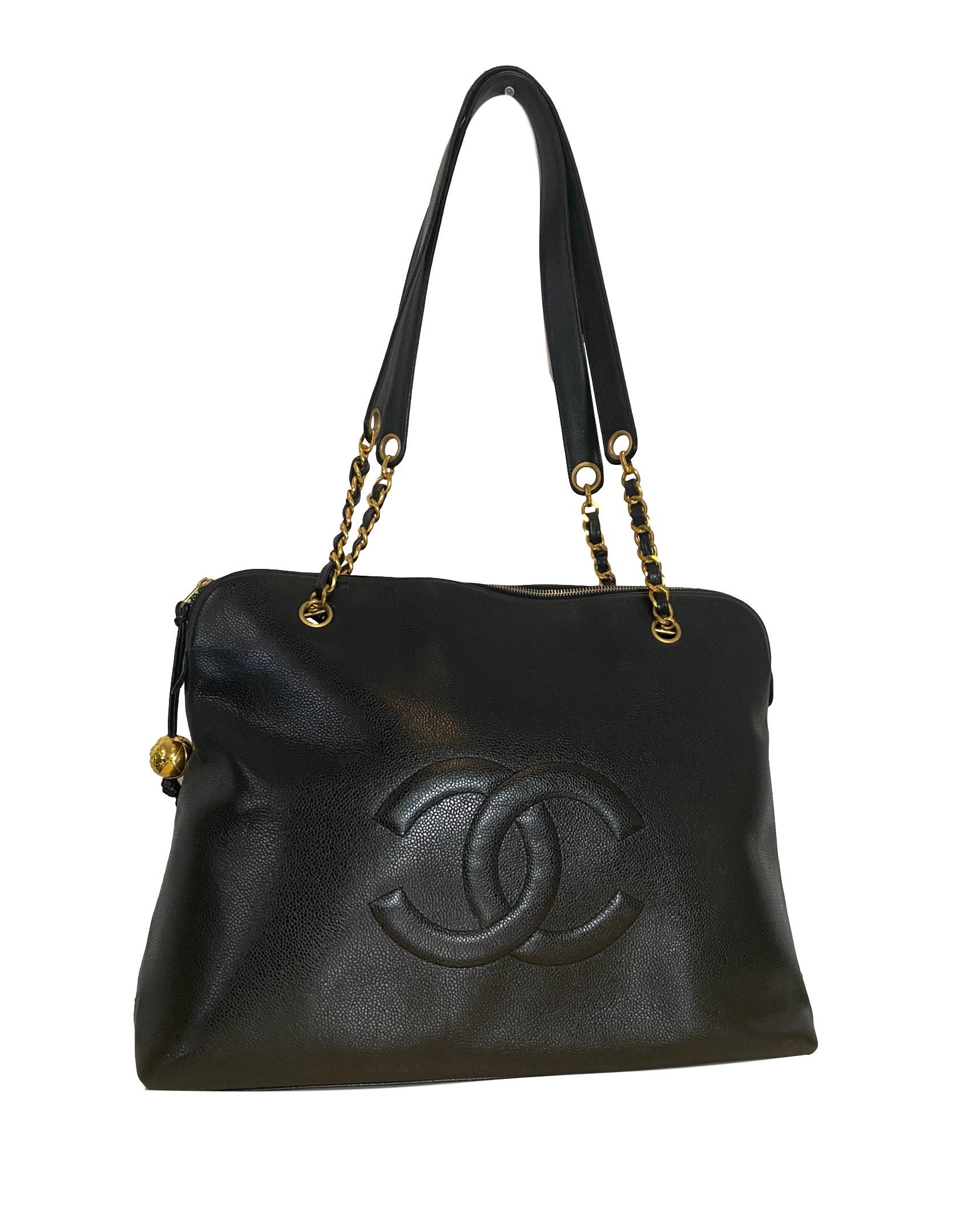 Vintage 1990's Timeless Large Black Leather Tote in Black Caviar Leather, circa 1994. Crafted from black caviar leather, this classic Chanel Logo tote bag features chain and leather straps, a top zip fastening, and a signature interlocking Chanel