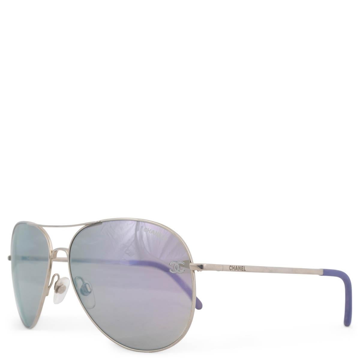 100% authentic Chanel 4189 pilot sunglasses with chrome lenses and a light tone titanium frame. Features calf skin details in lavender on the handle-ends. Has been worn and is in excellent condition. Has been worn and comes with case and