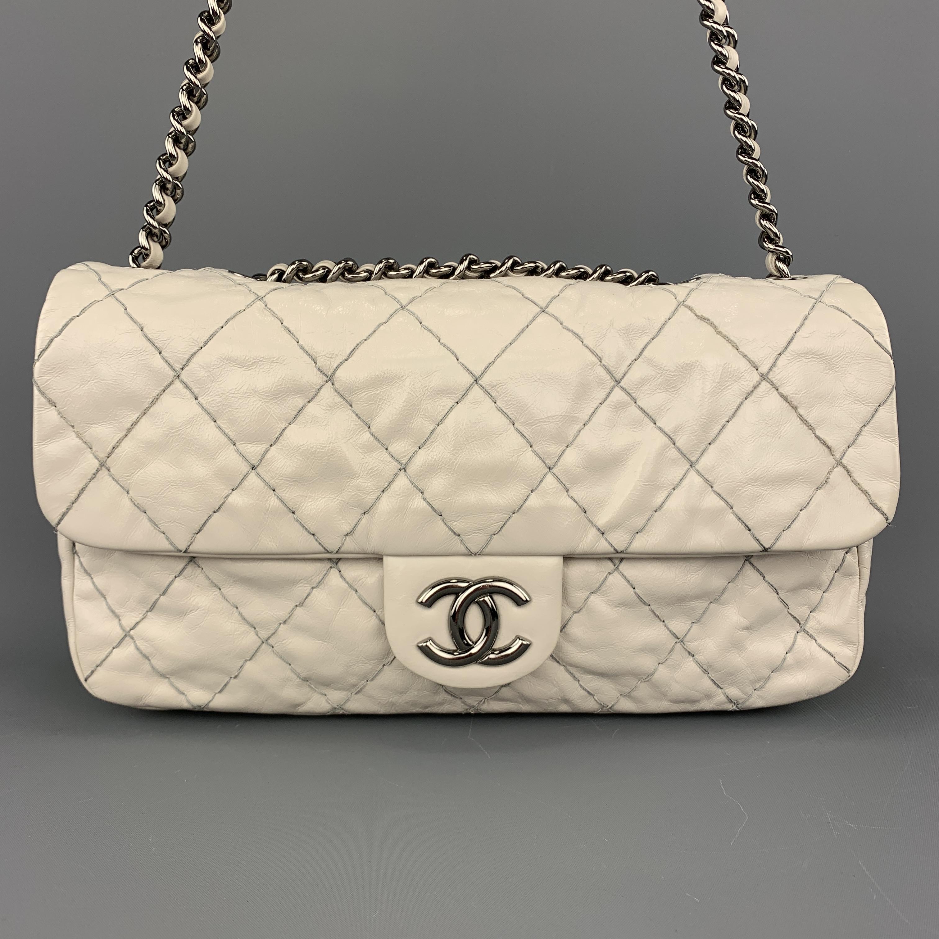 This rare CHANEL medium shoulder bag comes in creamy beige leather with all over thick top stitch pattern, top snap flap with dark silver tone CC emblem, double woven chain strap, and twill liner with zip pocket. Minor discoloration throughout