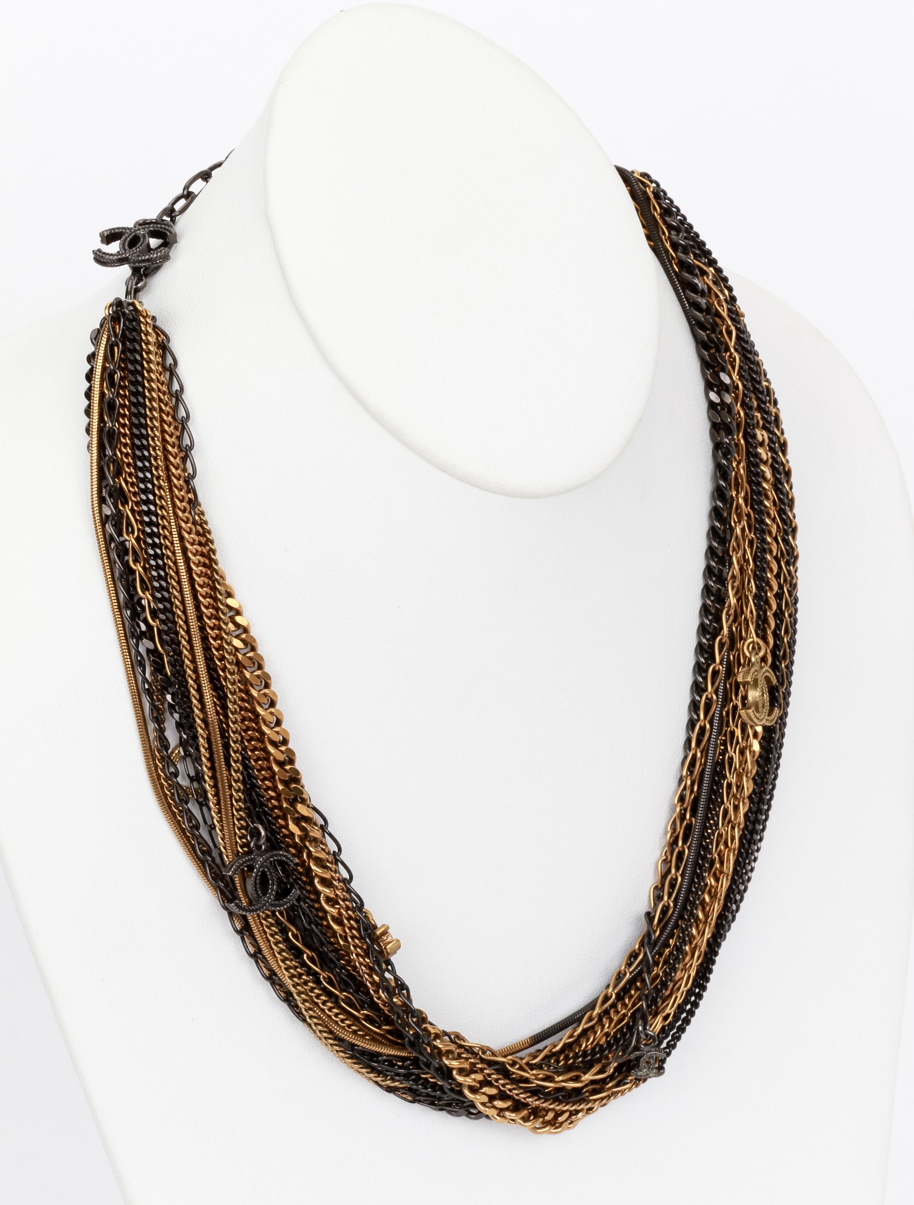 Chanel torsade chain necklace with twenty two different chain in black and gold color playing on layers and texture to create a compelling look. CC logo charms and clasp with adjustable length. Comes with original pouch.