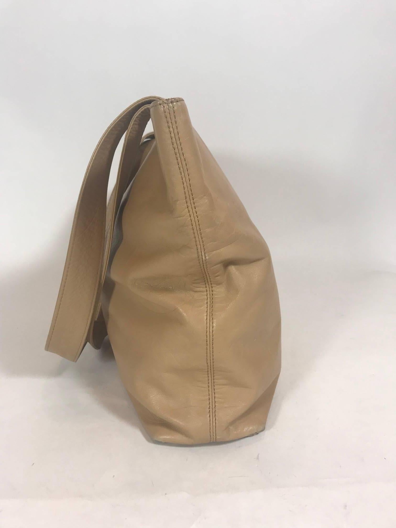 This Chanel Beige Leather Tote Bag, made In Italy, has multiple interlocking CC logo on both the front and back panel of the tote. This tote opens to a fabric interior, contains two inside pockets and can be fastened using the magnetic closure.