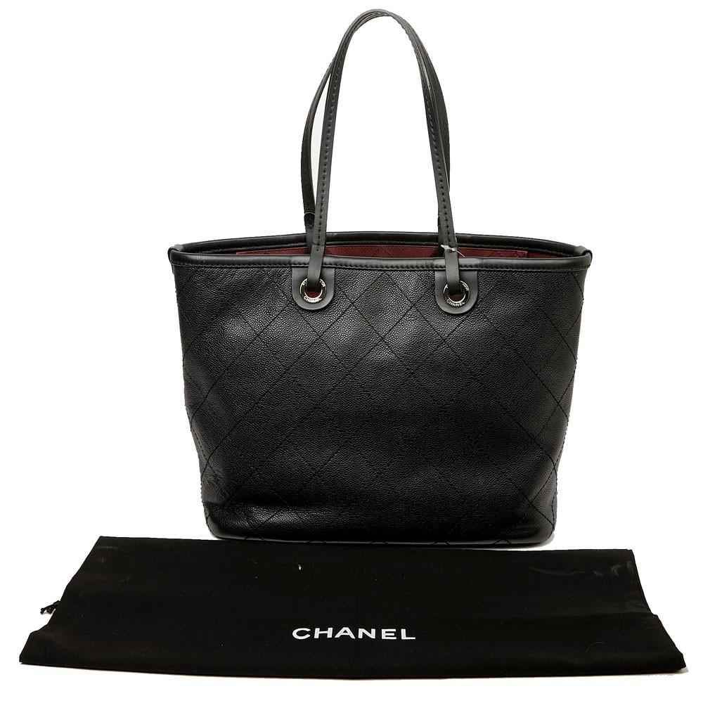 Chanel tote bag in black caviar leather. It is lined with burgundy canvas with 2 big pockets, and one with a zipper.  Silver metal hardware. 
Included : Hologram 1931.. and authenticity card. It comes from 2014. 
Worn by hand or on the shoulder by