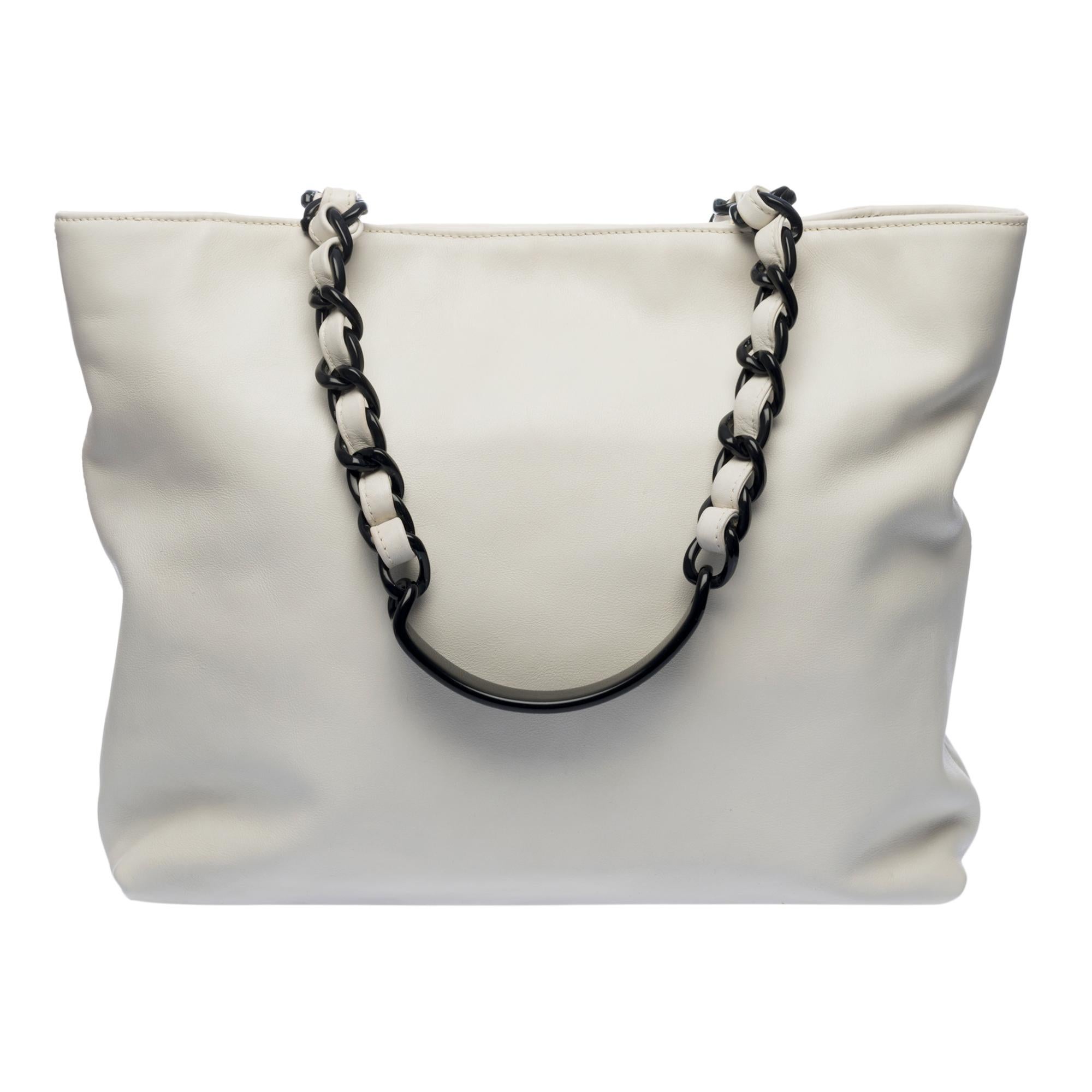 Chanel Tote Bag in white lambskin, gold-tone metal hardware and black plastic handle intertwined with white leather for shoulder support
White canvas lining, 1 zipped pocket
Closure with magnetic buttons
Signature: 