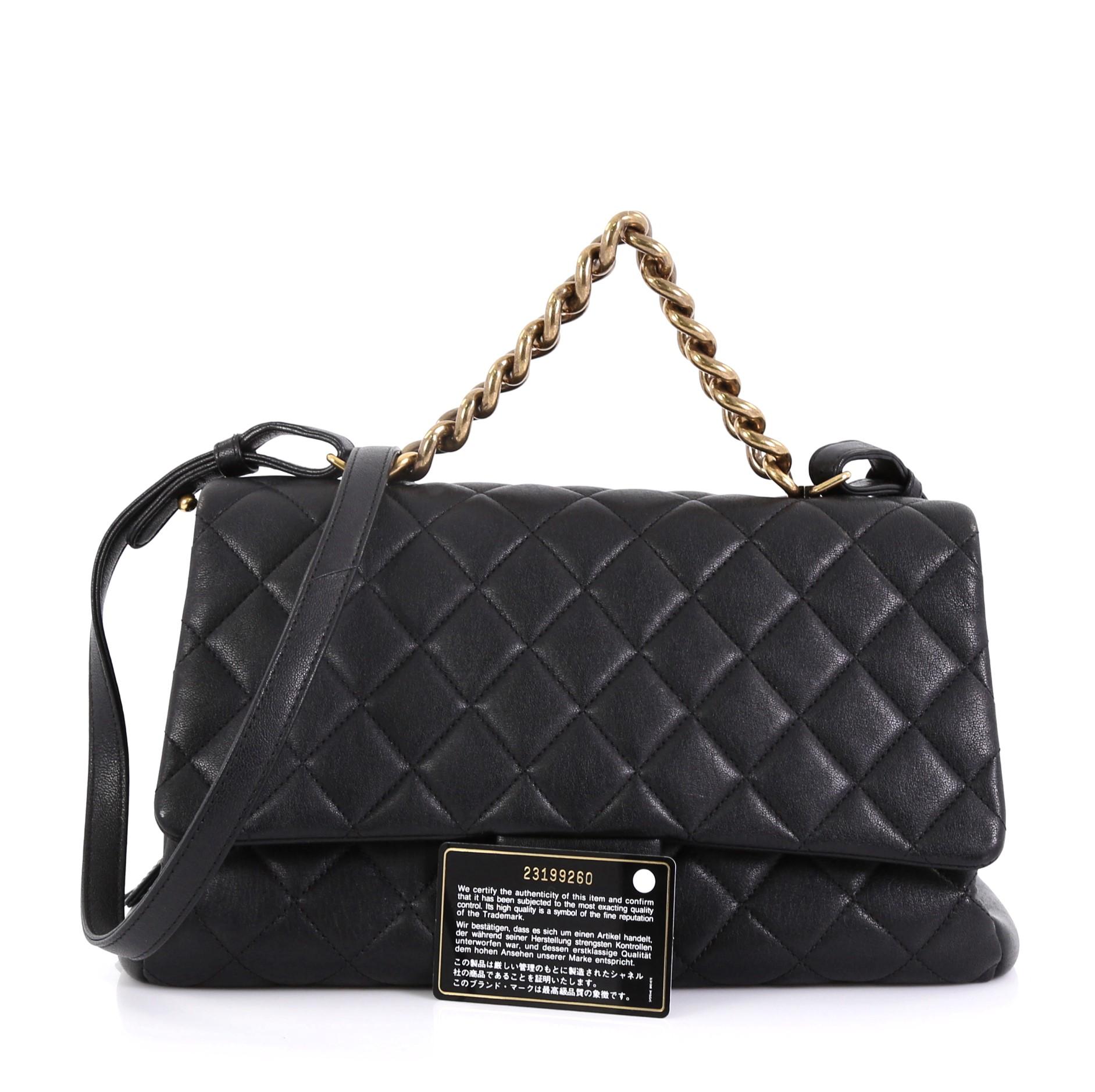 This Chanel Trapezio Flap Bag Quilted Sheepskin Large, crafted in black quilted sheepskin, features chain link strap with leather pad, exterior back slip pocket, protective base studs, and aged gold-tone hardware. Its CC turn-lock closure opens to a