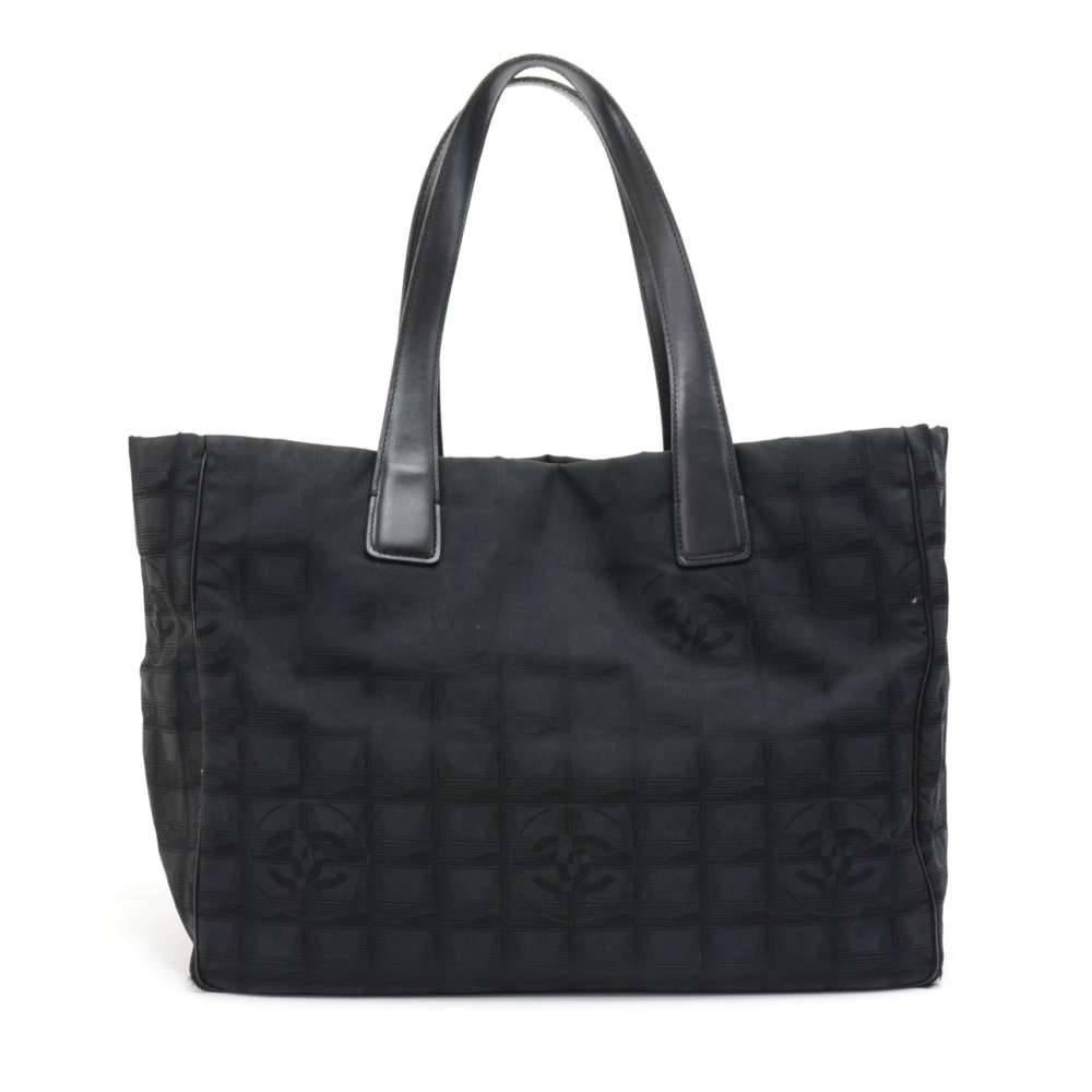 Chanel Travel Line Tote Bag in Jacquard nylon. Outside has black leather should straps and piping with metal studs on the bottom to protect your bag. Inside has black washable lining with 2 zipper pockets and a leather strap with a clasp to hold