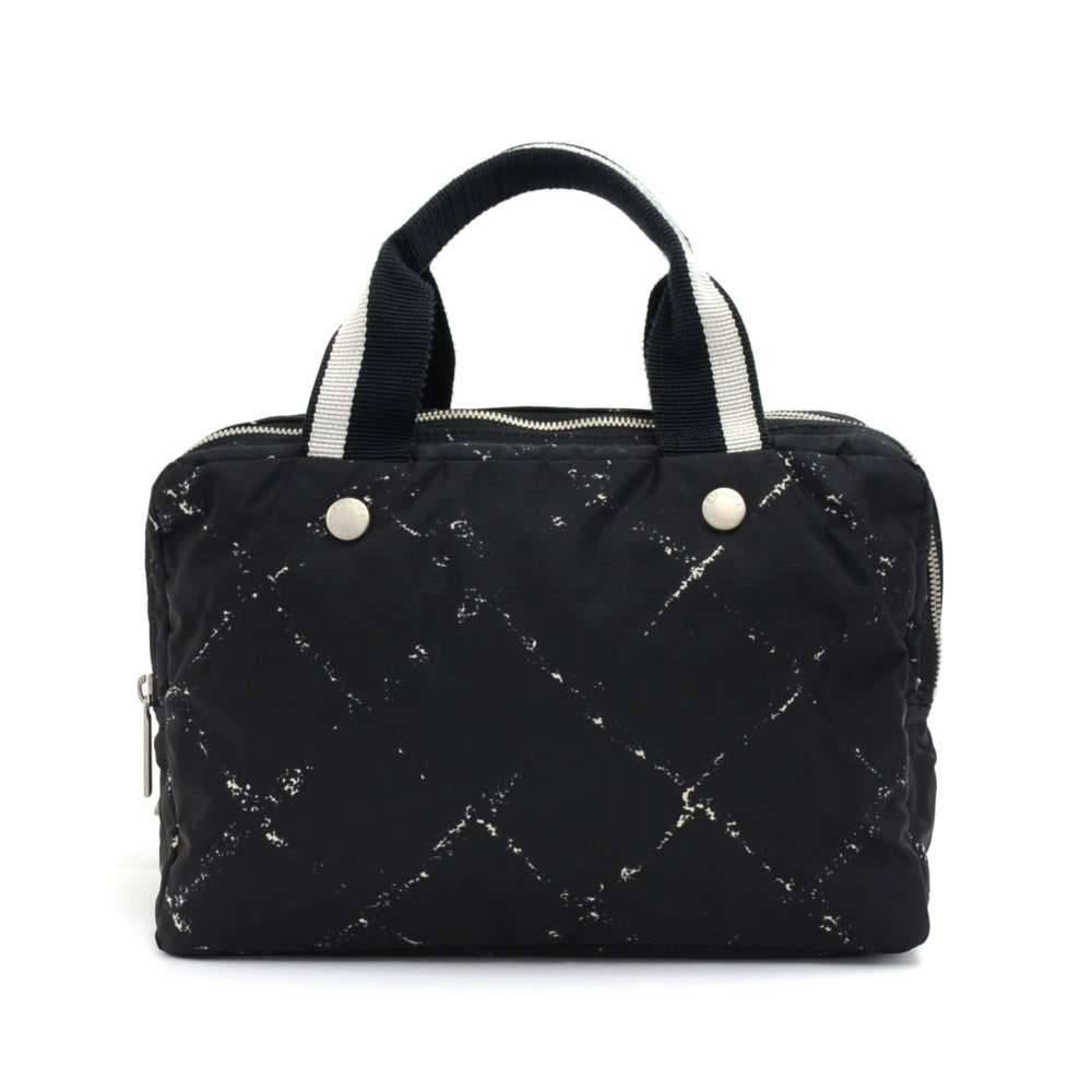 Authentic Chanel Travel line hand bag in black x White nylon. It has 3 separated compartment with zipper closures. Inside has vinyl water-repellant lining. Comfortably carried in hand. Great for storing your cosmetics and toiletries while you