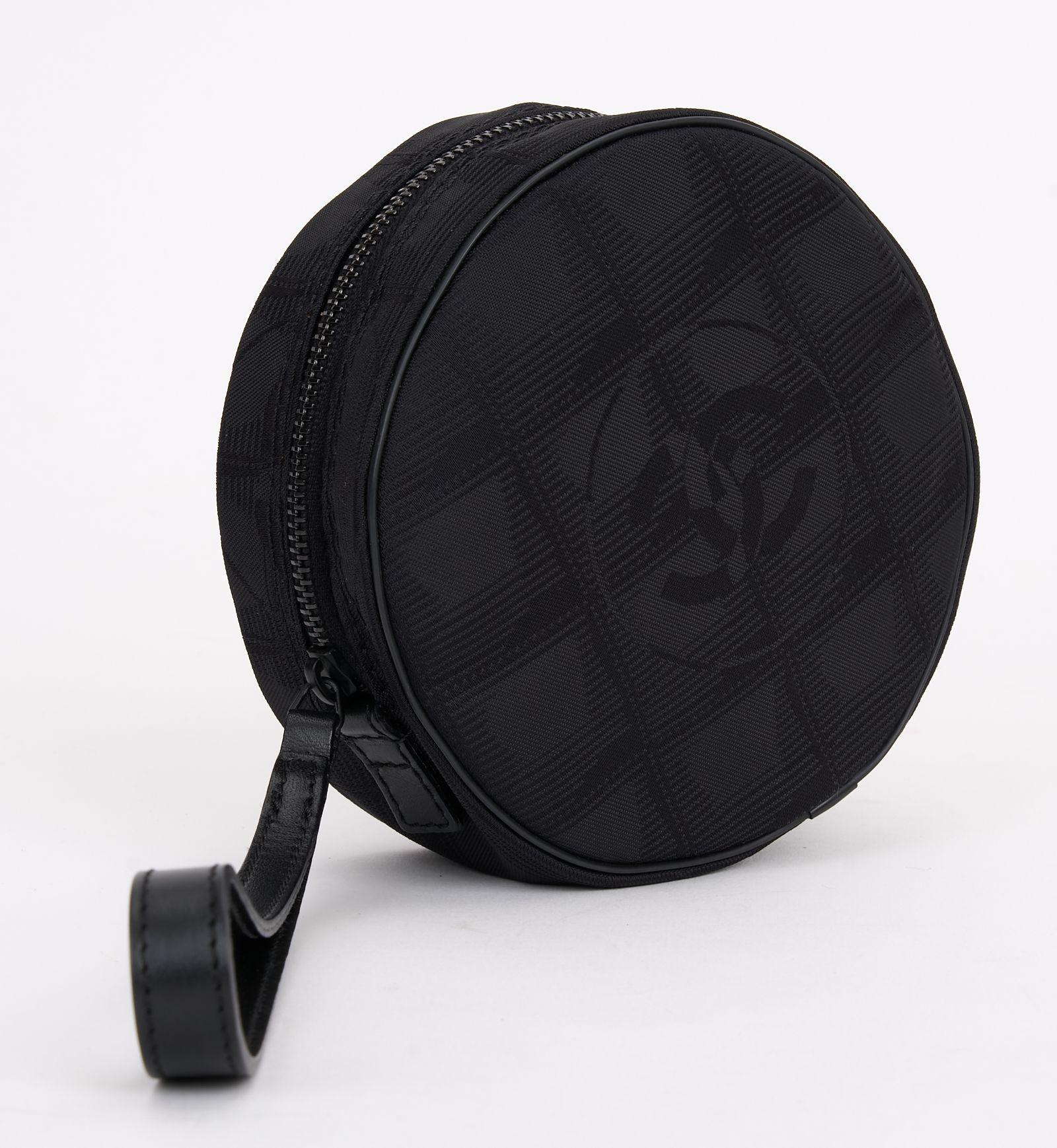 Diese runde Chanel Travel Line Tasche aus schwarzem Jacquard-Nylon hat einen Reißverschluss, ein schwarzes Innenfutter und ein offenes Fach. Dies ist ein perfektes Accessoire für den täglichen Gebrauch oder um Ihre persönlichen Gegenstände an ihrem