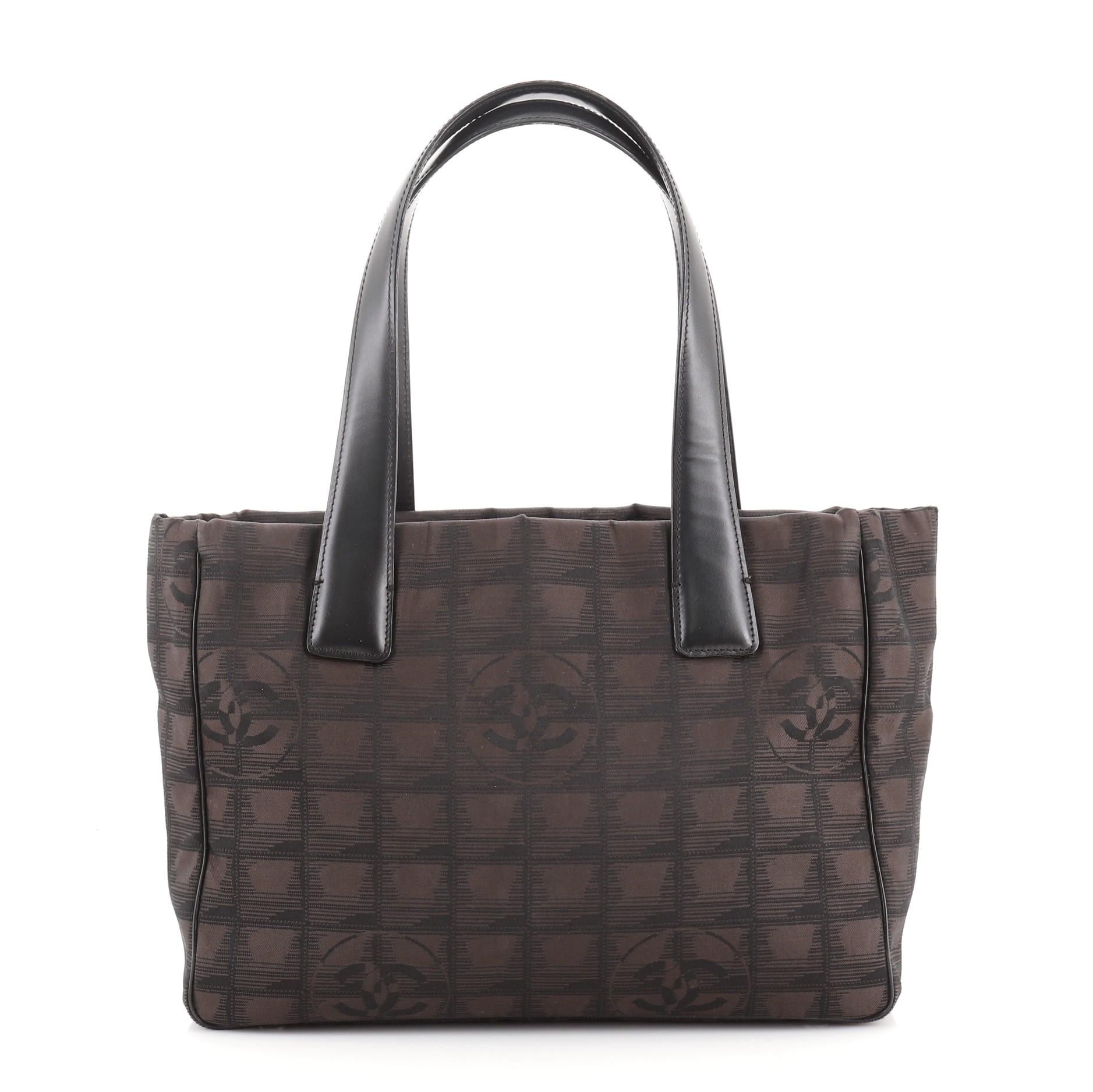 Chanel Travel Line Tote Nylon Small
Black Brown Nylon

Condition Details: Moderate wear and discoloration on exterior corners, creasing near base, splitting and peeling on handle wax edges. Small stains in interior, scratches on
