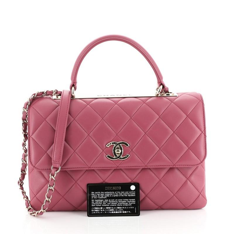 This Chanel Trendy CC Top Handle Bag Quilted Lambskin Medium, crafted from pink quilted lambskin, features a leather top handle, woven-in leather chain strap with leather pad, and gold-tone hardware. Its turn-lock closure opens to a pink leather