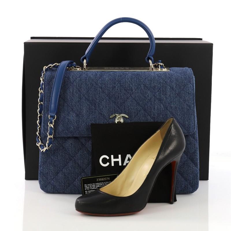 This Chanel Trendy CC Top Handle Bag Quilted Denim Large, crafted in blue quilted denim, features flat leather top handle, woven-in leather chain strap with leather pad, exterior back slip pocket, and gold-tone hardware. Its turn-lock closure opens