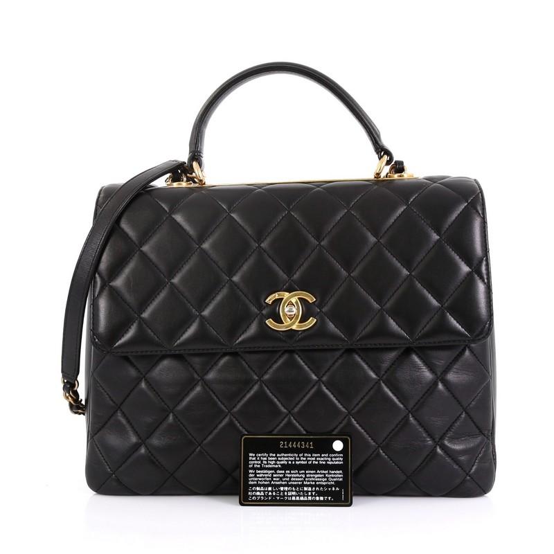 This Chanel Trendy CC Top Handle Bag Quilted Lambskin Large, crafted from black quilted lambskin, features a leather top handle, woven-in leather chain strap with leather pad, exterior back slip pocket, and gold-tone hardware. Its turn-lock closure