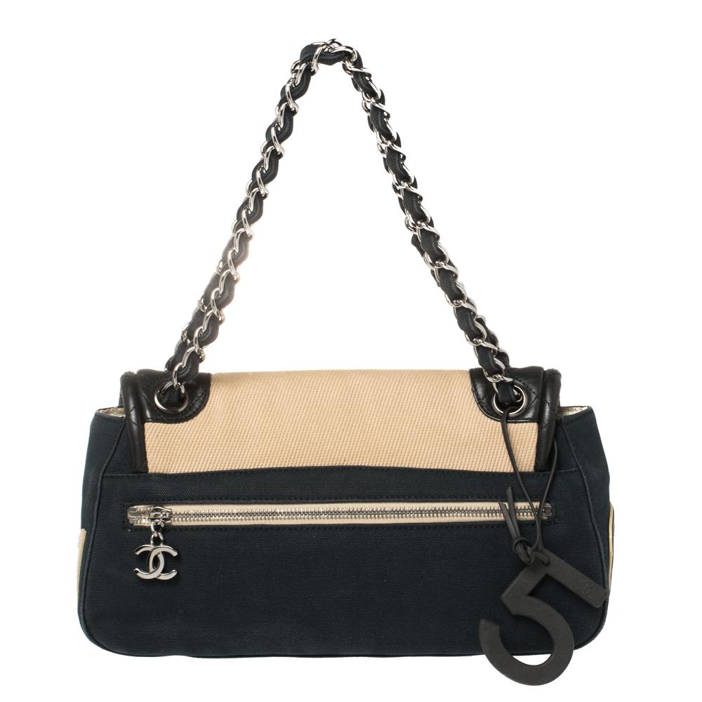 This flap bag from Chanel has been designed to be a worthy style companion! Crafted from canvas and leather, the bag is packed with the brand's signature elements, like the CC, '31', No.5 charm, and a woven chain link. The Mademoiselle lock on the