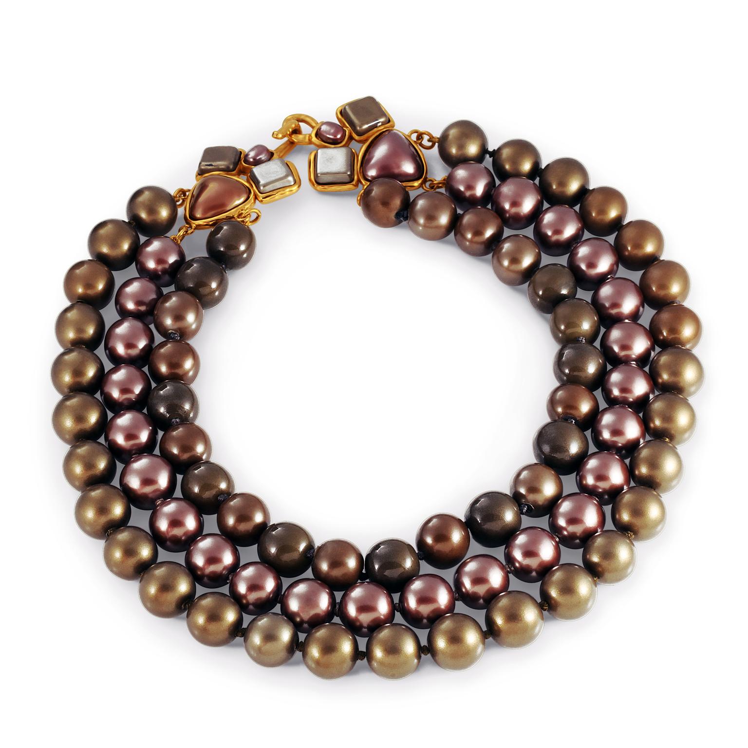 This authentic Chanel Tri Color Triple Row Necklace is in excellent condition from the early 1990’s.  Three rows of beads create a statement choker.  Subtle metallic hues of burgundy, dark chocolate and dark gold. Ornamental geometric clasp. Made in