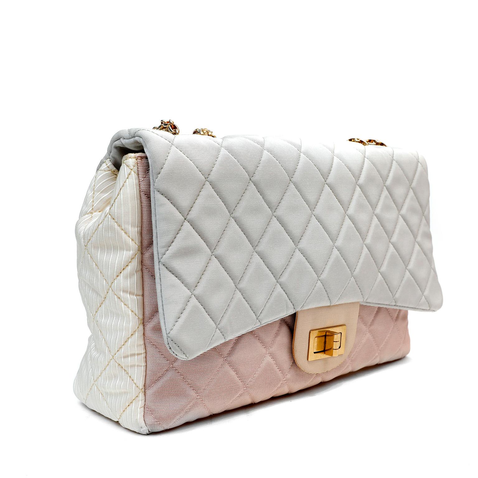 This authentic Chanel Tricolor Fabric Reissue Flap Bag is in good previously owned condition.  It is a beautiful version of the iconic reissue in feminine pastel colors.  Grosgrain fabric is quilted in signature Chanel diamond pattern in shades of