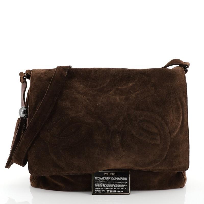 This Chanel Triple CC Messenger Suede Medium, crafted from brown suede, features suede shoulder strap, triple-stitched CC logo on its front flap, and aged silver and gunmetal-tone hardware. It opens to a brown satin interior. Authenticity code