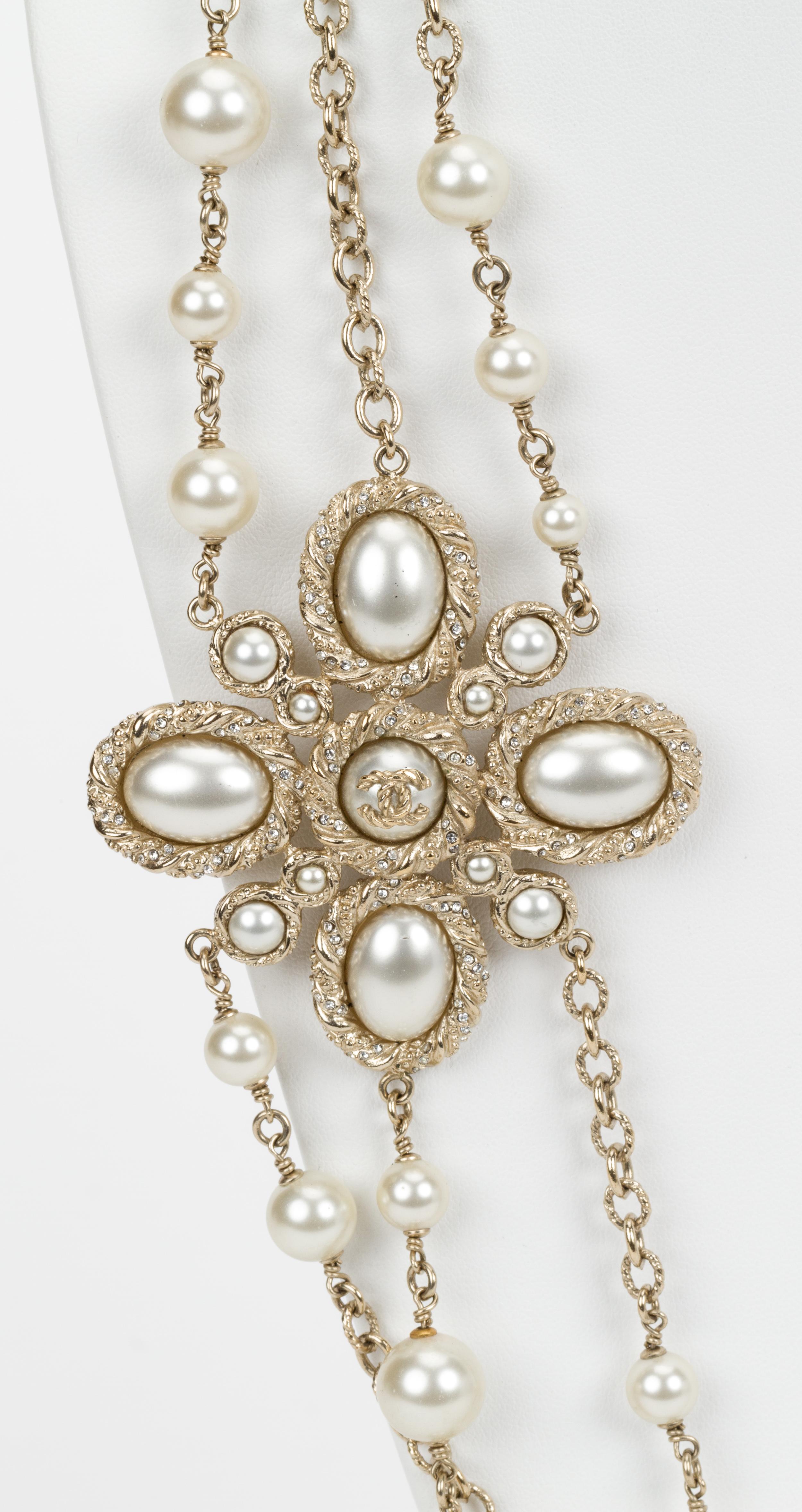 Chanel triple strand pearl necklace with side accent cross piece. Autumn 2013 collection. Comes with original box.